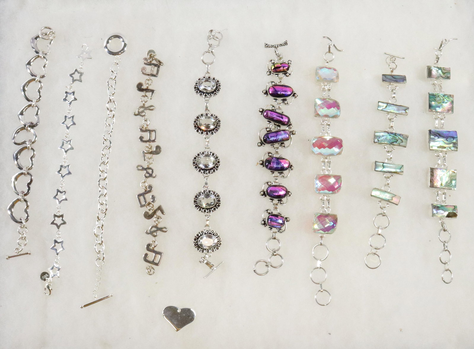 LOT OF STERLING SILVER BRACELETS: (9) WITH HEART CHARM. ALL MARKED .925 Dimensions: LONGEST 8 1/2" L Terms: Hartzell's Auction Gallery will handle most of the shipping in-house. WE do reserve the right to not ship some large items, la