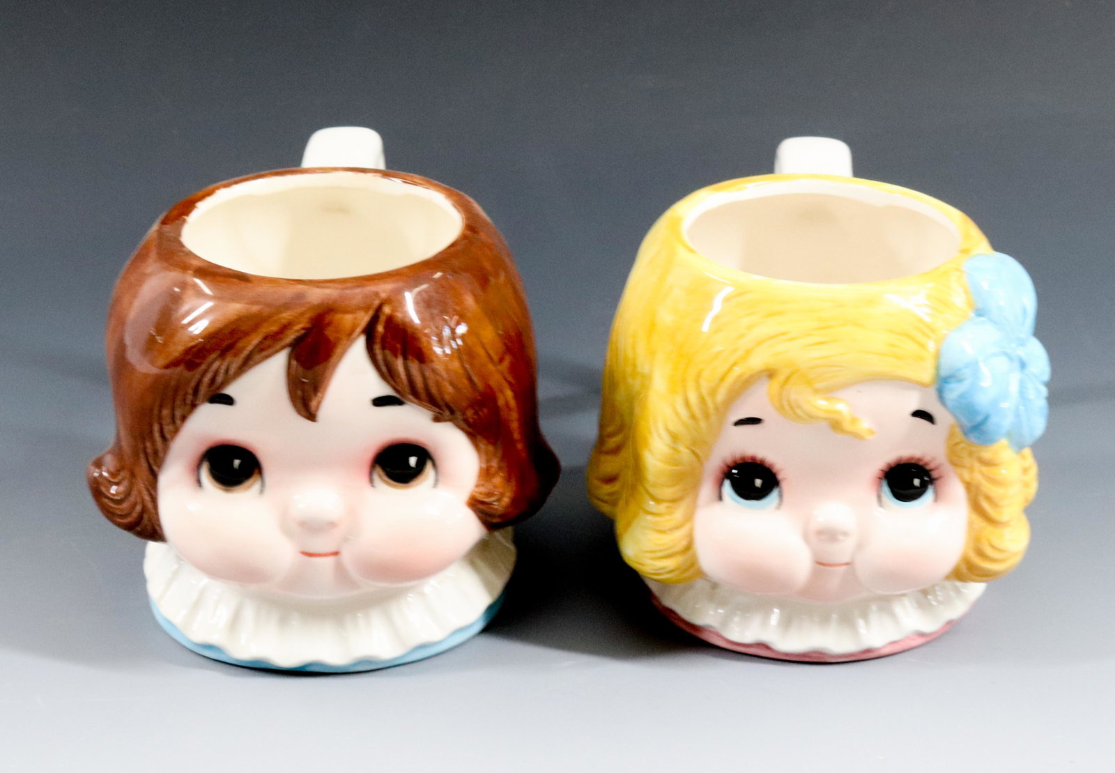 DOLLY DINGLE AND BILLY BUMPS MUGS: HOUSE OF GLOBAL ART 1982 Dimensions: 3 3/4" H Terms: Hartzell's Auction Gallery will handle most of the shipping in-house. WE do reserve the right to not ship some large items, larger lots of glasswar