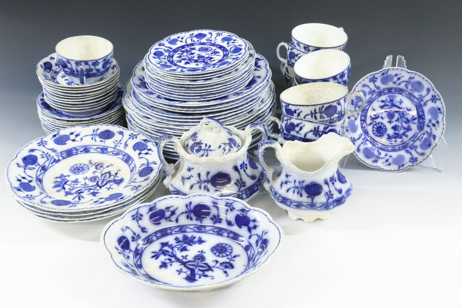 BLUE ONION FLOW BLUE SET: JOHNSON BROS ENGLAND HOLLAND PATTERN LIDDED SUGAR, CREAMER, OVAL BOWL, (10) CUPS, 10 SAUCERS, (10) 10" DINNER PLATES, (6) 9" LUNCHEON PLATES, (7) 7" DESSERT PLATES, (4) 6 1/4" BREAD PLATES, (4) SOUP B