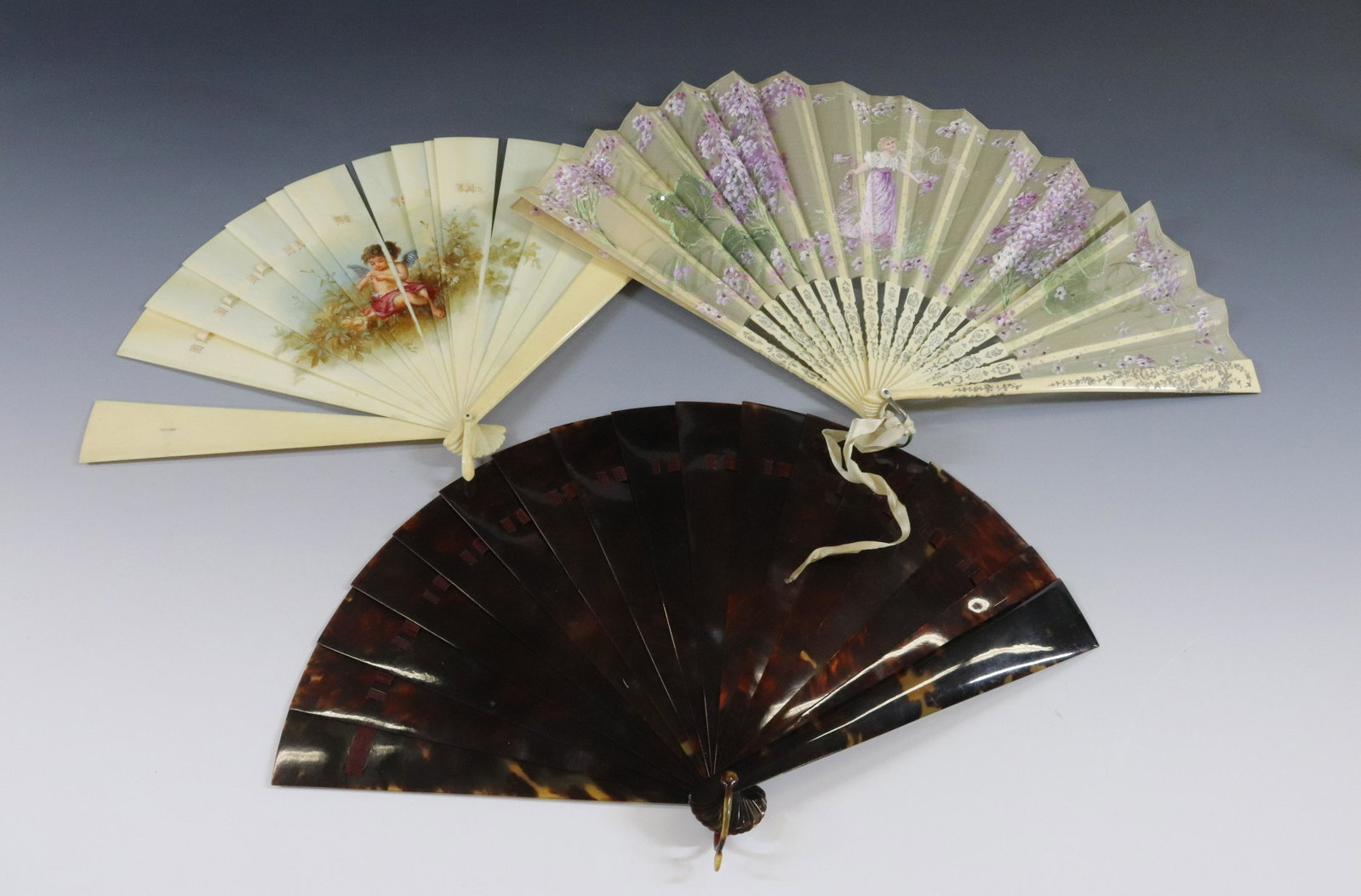 VICTORIAN FAN GROUP: (3) FANS INCLUDING HAND PAINTED CUPID AND BOW ON BONE, HAND PAINTED TEXTILE YOUNG MAIDEN, AND CARVED TURTLE SHELL DIMENSIONS: 9" X 15" OPEN TERMS: Hartzell's Auction Gallery will handle most of the sh