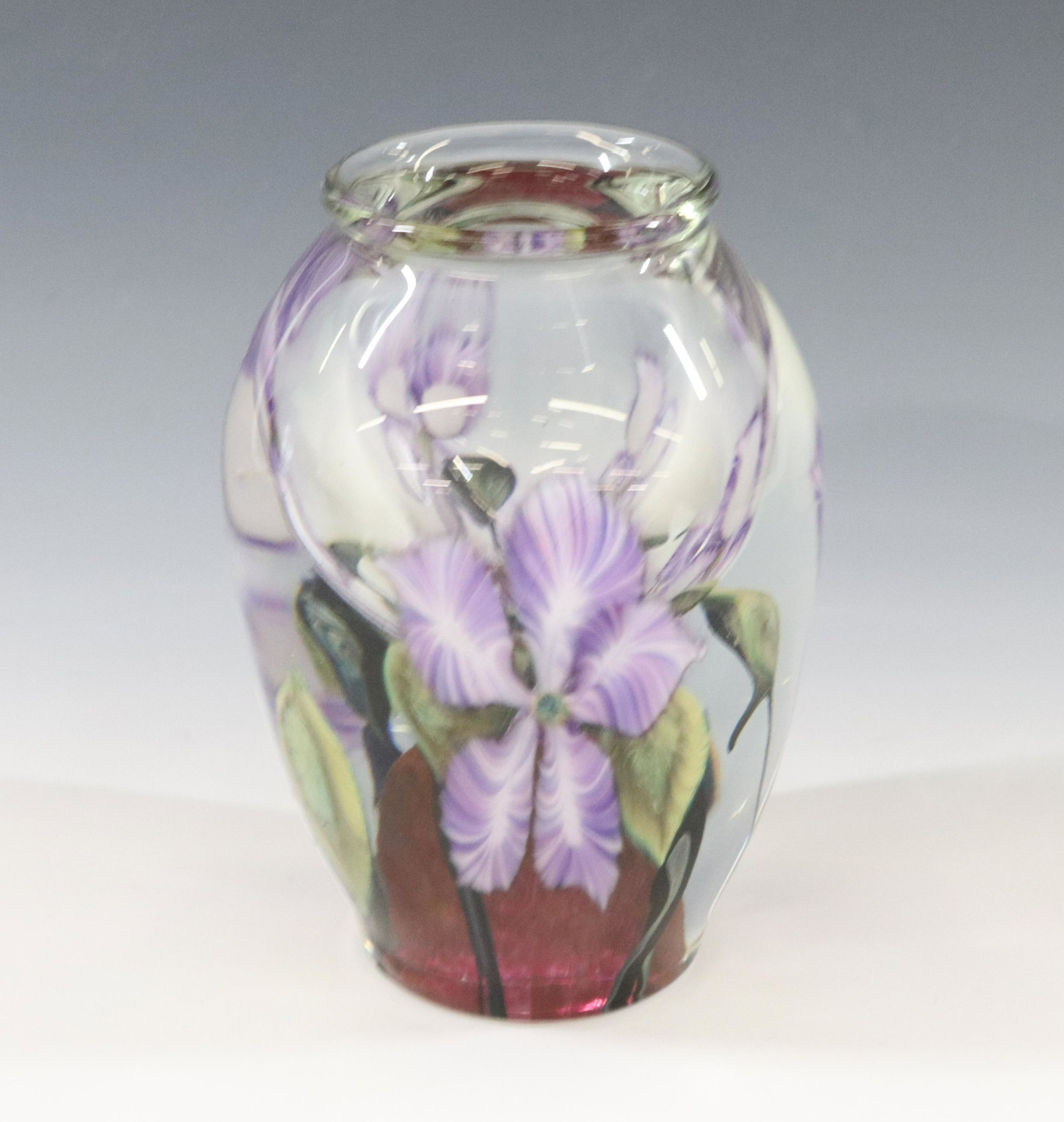 LOTTON STUDIO ART GLASS VASE: PAPERWEIGHT BASE WITH IMBEDDED LAVENDER FLOWERS SIGNED ON BASE 1991 DIMENSIONS: 5"H X 3 1/4" TERMS: Hartzell's Auction Gallery will handle most of the shipping in-house. WE do reserve the right to not