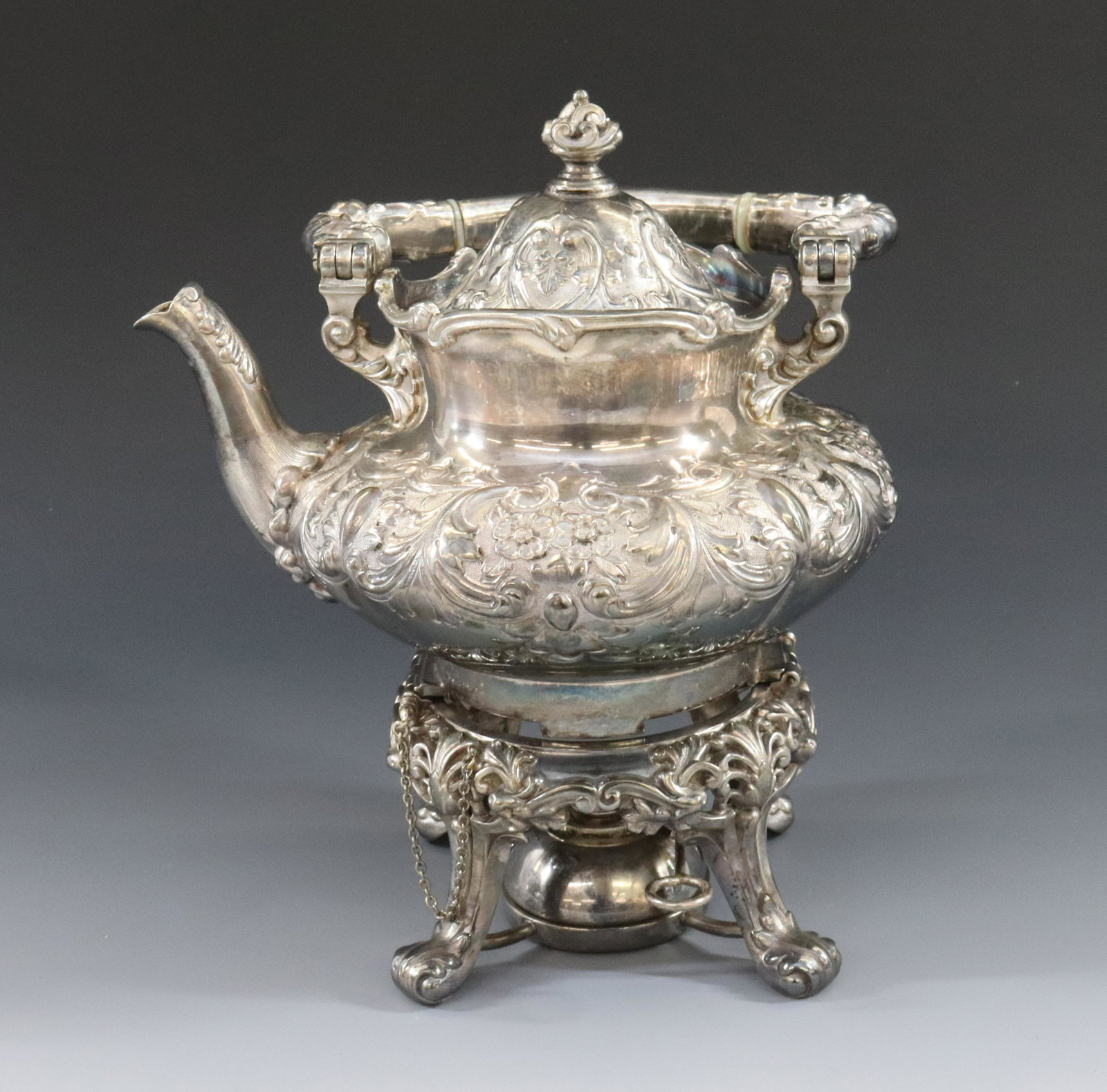 VICTORIAN SILVERPLATE TEA POT ON STAND: SOUTHINGTON SILVER CO. CT. ORNATE ROCOCO DESIGN COMPLETE WITH BURNER, PINS AND CHAINS DIMENSIONS: 10" X 9" TERMS: Hartzell's Auction Gallery will handle most of the shipping in-house. WE do reserve th