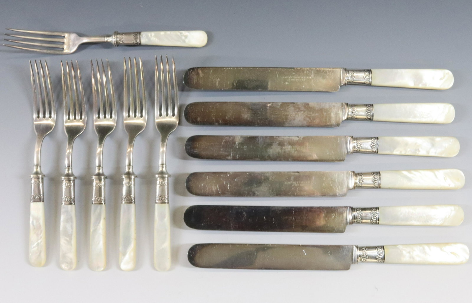 SILVER PLATE AND MOTHER OF PEARL FLATWARE: (12) KNIVES AND FORKS SILVER PLATE BLADES AND STERLING SILVER BANDS DIMENSIONS: KNIFE 9" FORK 7 1/4" TERMS: Hartzell's Auction Gallery will handle most of the shipping in-house. WE do reserve the righ