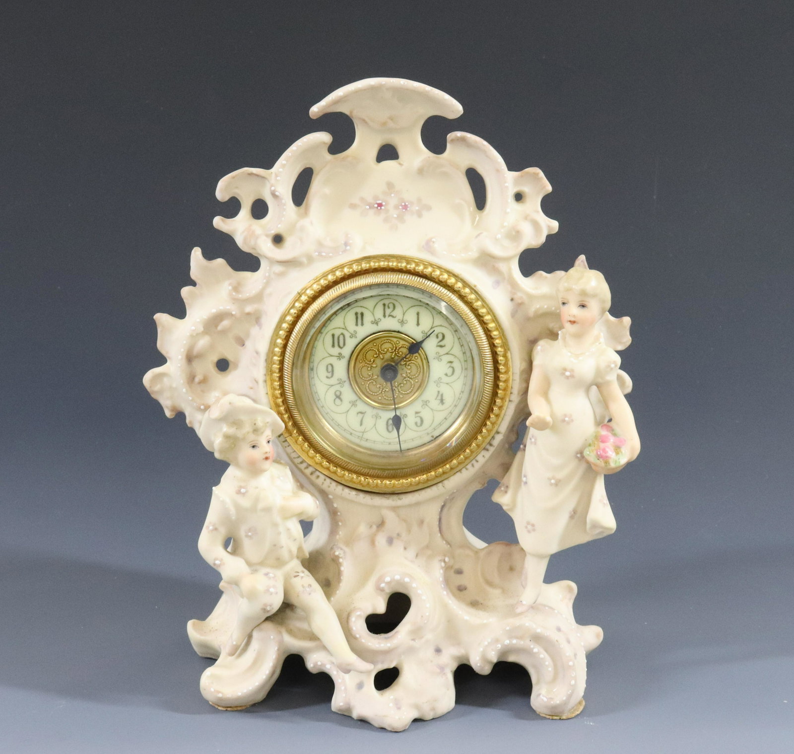 BISQUE PORCELAIN CLOCK: ROMANTIC THEME WITH ENAMEL DIAL MADE IN GERMANY WITH R IN SHIELD DIMENSIONS: 7" X 5 1/2" TERMS: Hartzell's Auction Gallery will handle most of the shipping in-house. WE do reserve the right to not shi