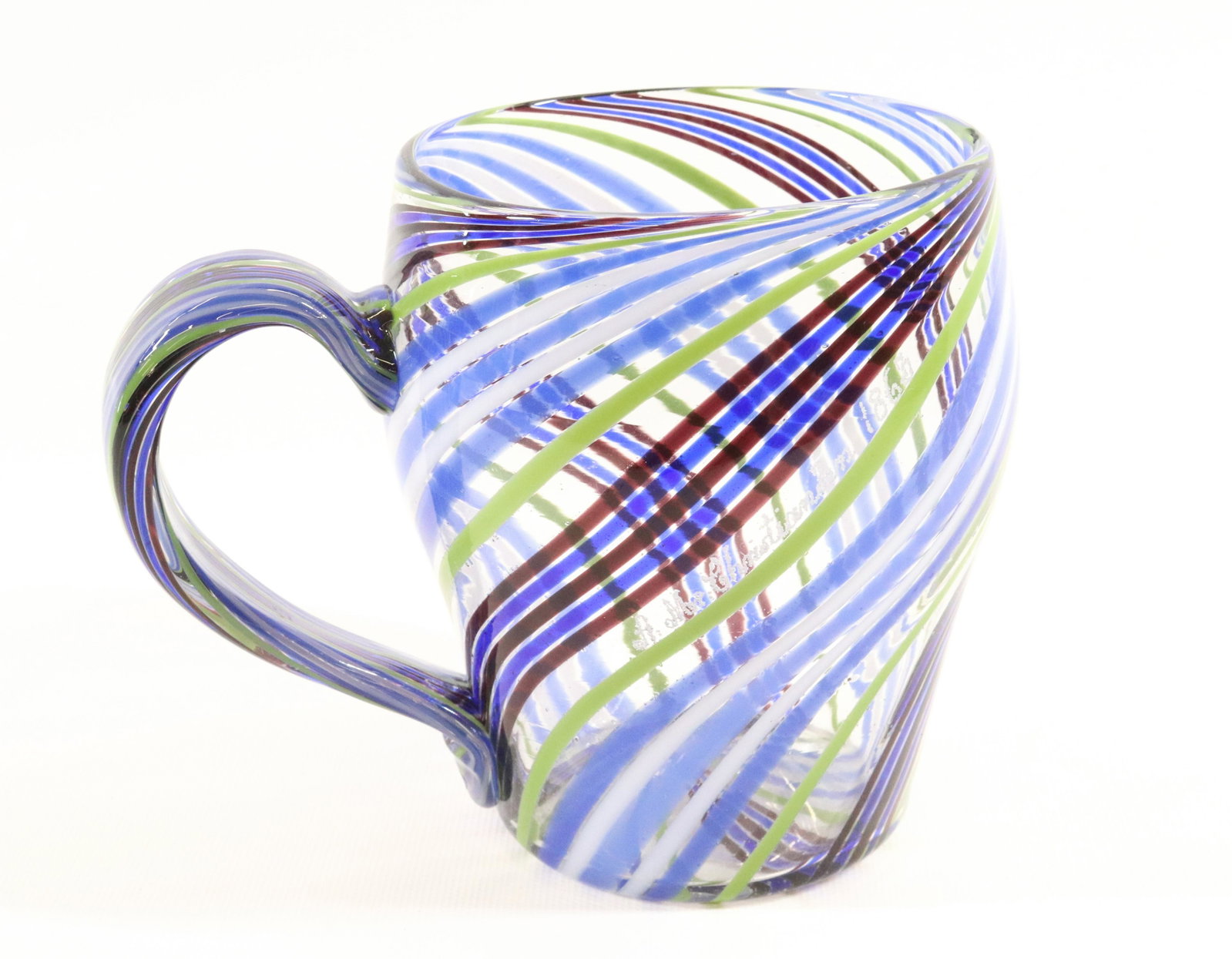 BLOWN GLASS MUG 1863: RIBBONS OF COLORED GLASS SWIRLED MUG AND HANDLE "A. MR. CHRISTIANSEN 1863" IN SCRIPT HIGH POINT WEAR ON BASE WITH ROUGH PONTIL DIMENSIONS: 5"H X 6 1/2" TERMS: Hartzell's Auction Gallery will handle mo