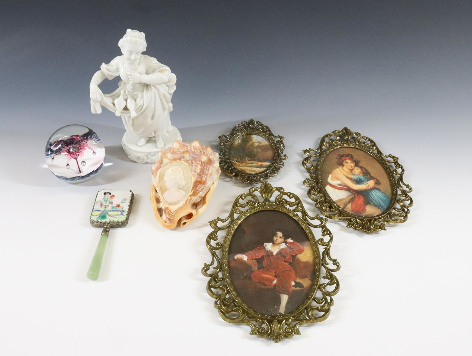 DECORATIVE GROUPING: (7) SELKIRK SCOTLAND PAPERWEIGHT, WHITE PORCELAIN GERMANY FIGURINE, CARVED CAMEO CONCH SHELL AND ASIAN HAND MIRROR AND (3) METAL OVAL PICTURE FRAMES DIMENSIONS: 3"H X 3" 7 1/2"H SHELL 5" X 3 1/2" TERM