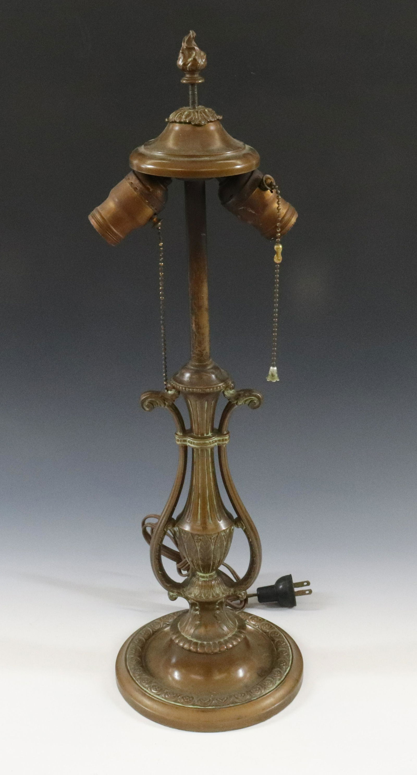 LIGHTOLIER ART DECO TABLE LAMP: URN FORM WITH TWO LIGHTS ORIGINAL CAP AND FINIAL BRONZE PLATED SPELTER NICE PATINA DIMENSIONS: 22"H X 6 3/4" TERMS: Hartzell's Auction Gallery will handle most of the shipping in-house. WE do reserve