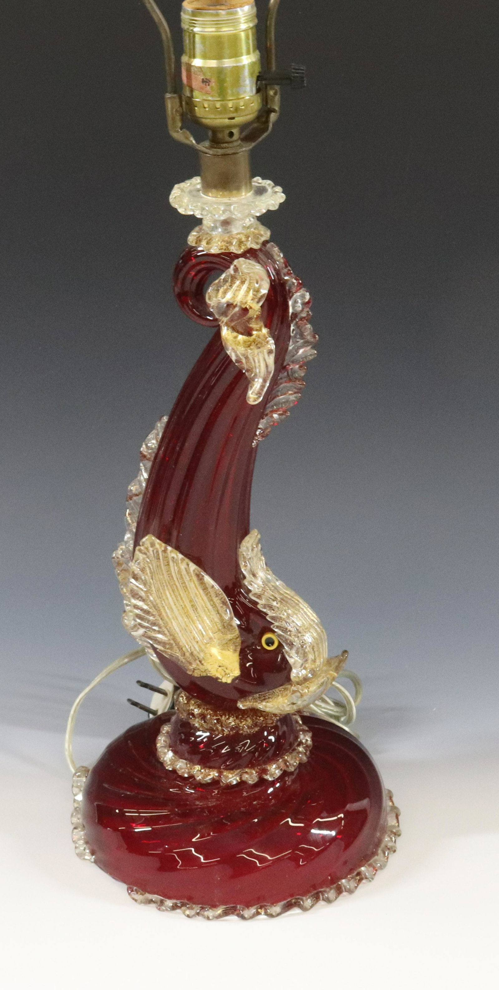 VENETIAN DOLPHIN LAMP: RED GLASS WITH CLEAR AND GOLD FLECKS DIMENSIONS: 24" TO TOP OF HARP TERMS: Hartzell's Auction Gallery will handle most of the shipping in-house. WE do reserve the right to not ship some large items, l