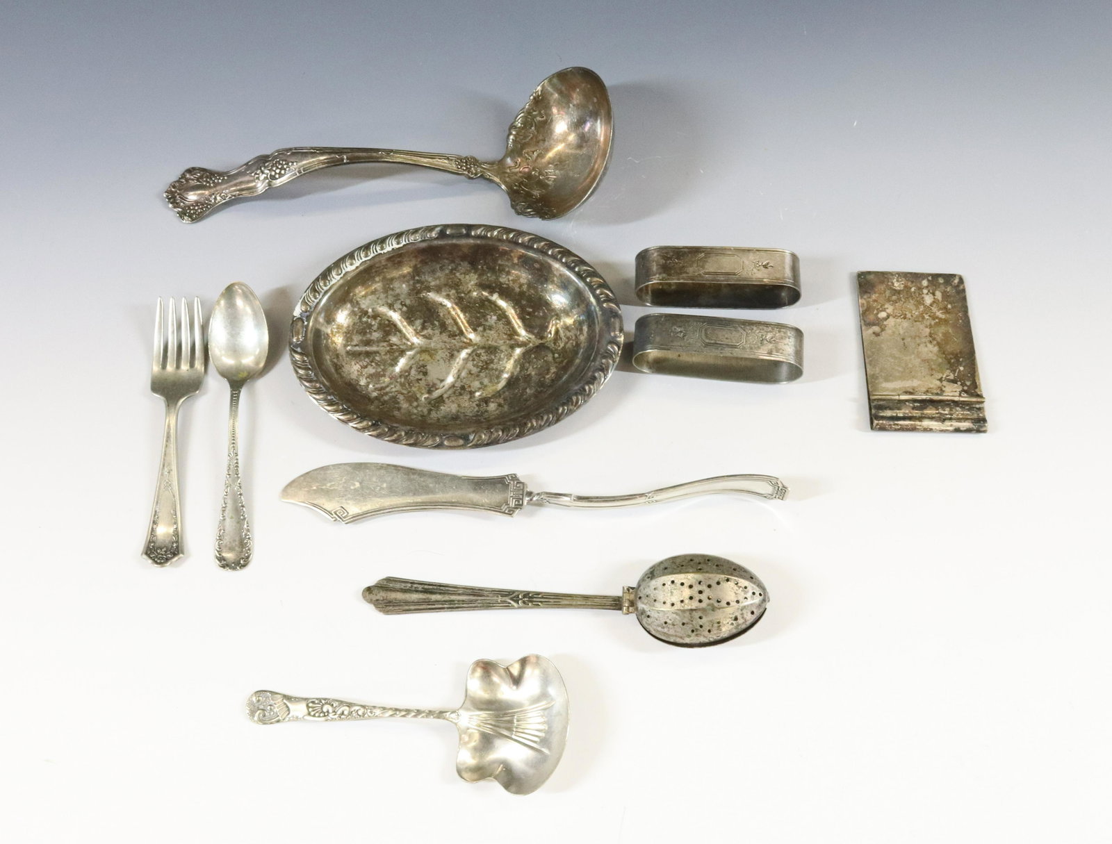 SILVER PLATE FLATWARE GROUPING: (10) FLATWARE TWO NAPKIN RINGS NOTEPAD COVER AND TEA INFUSER SPOON DIMENSIONS: 2 3/4" TO 7 1/4" TERMS: Hartzell's Auction Gallery will handle most of the shipping in-house. WE do reserve the right to 