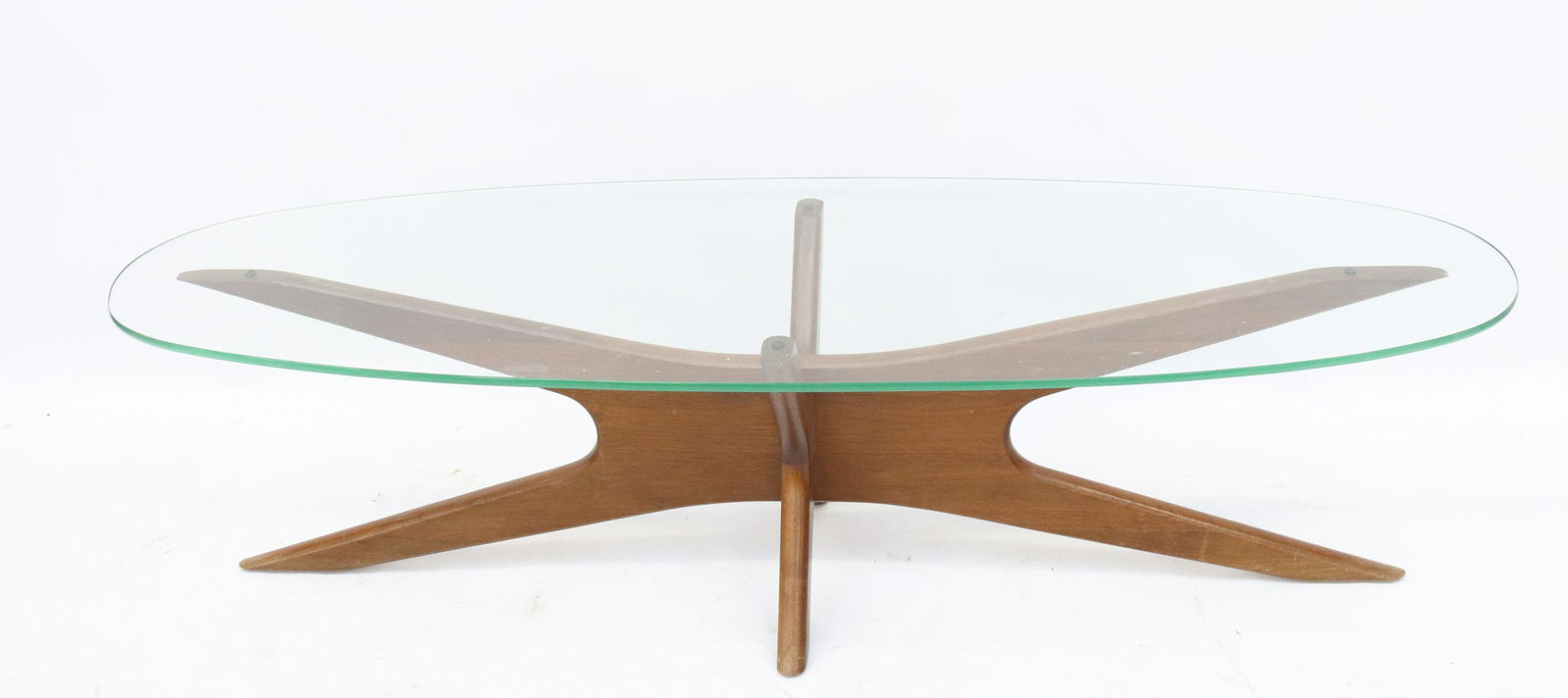 ADRIAN PEARSALL "JACKS" COFFEE TABLE: ADRIAN PEARSALL FOR CRAFT ASSOCIATES. MID-CENTURY WALNUT "JACKS" TABLE WITH AN ELONGATED OVAL GLASS TOP WITH BEVELED EDGE. UNMARKED DIMENSIONS: 15 1/2" X 59 1/2" X 19 3/4" TERMS: Hartzell's Auction Ga