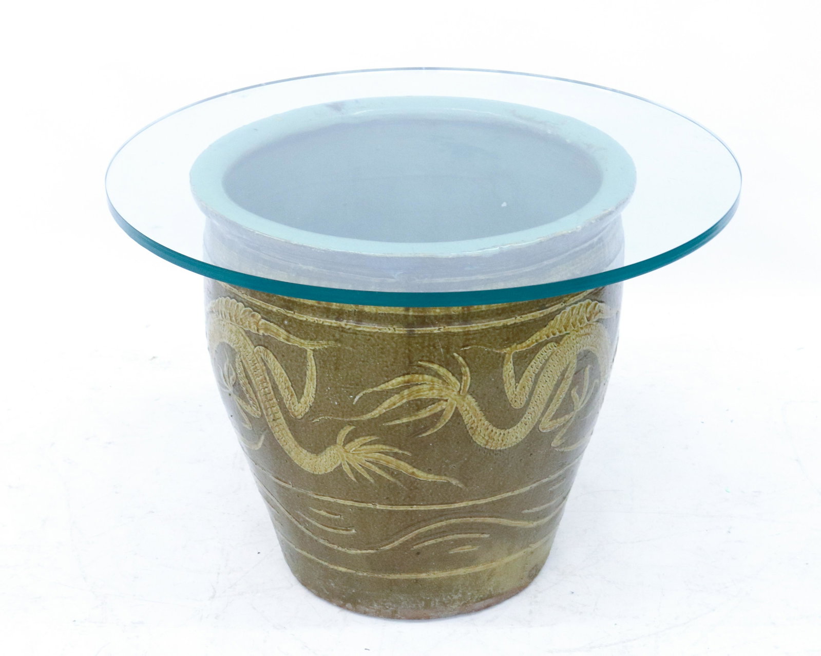 LARGE ASIAN GLAZED POT: DRAGON MOTIF ON EXTERIOR. GREEN GLAZED INTERIOR. ROUND GLASS TOP FOR USE AS END TABLE DIMENSIONS: 19 1/2" X 20". GLASS TOP IS 28" D TERMS: Hartzell's Auction Gallery will handle most of the shipping i
