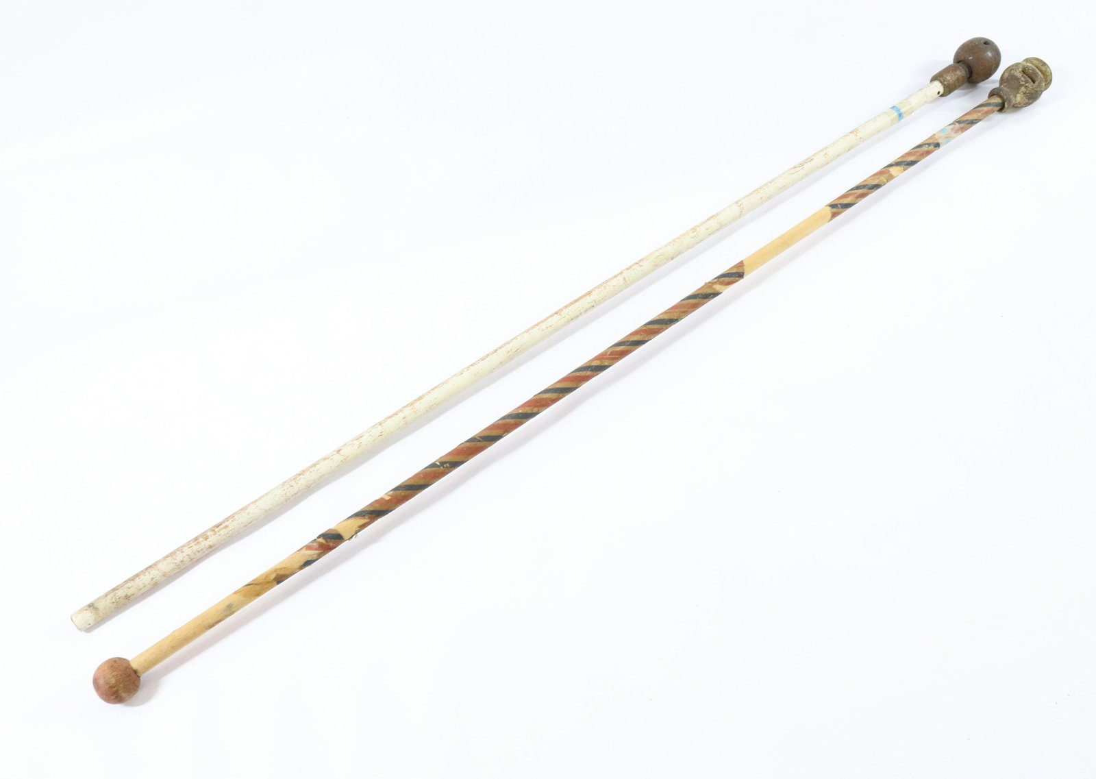 PR. OF FOLK ART CANES: (2) CAP GUN CANES - WOODEN SHAFTS WITH METAL TOPS PAINTED AND ROLLED PAPER SURFACES Size: 31"AND 32" L Terms: Hartzell's Auction Gallery will handle most of the shipping in-house. WE do reserve the ri