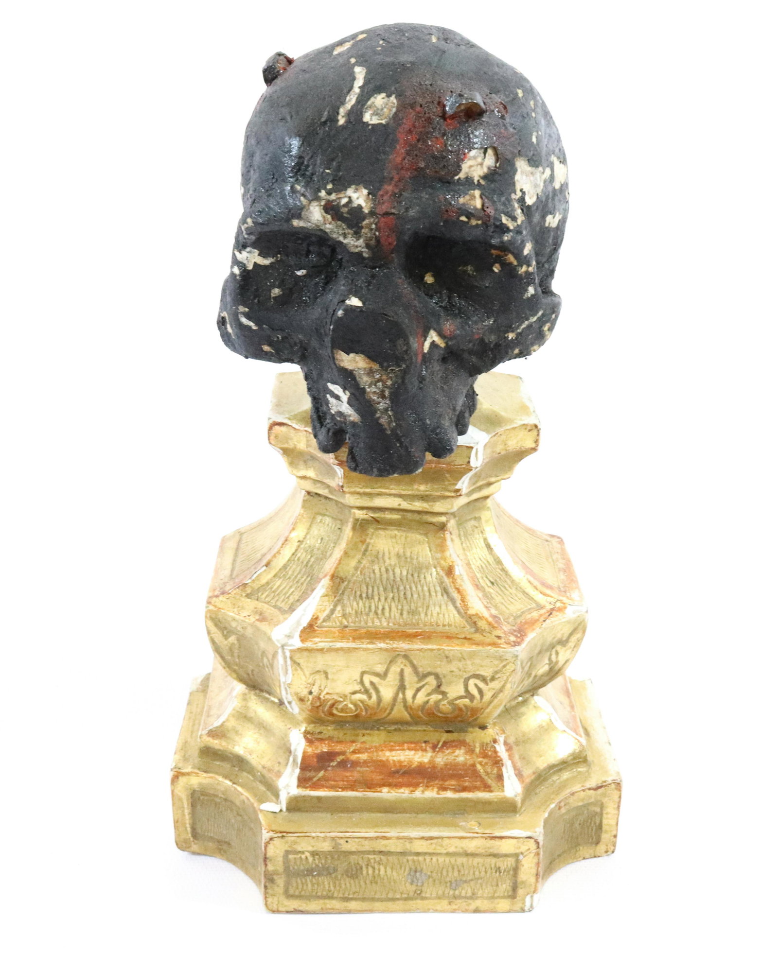 FOLK ART PAINTED SKULL: HAND CARVED WOODEN SKULL WITH BLACK PAINT, ON GILDED WOODEN BASE Size: 8 3/4" H Terms: Hartzell's Auction Gallery will handle most of the shipping in-house. WE do reserve the right to not ship some la