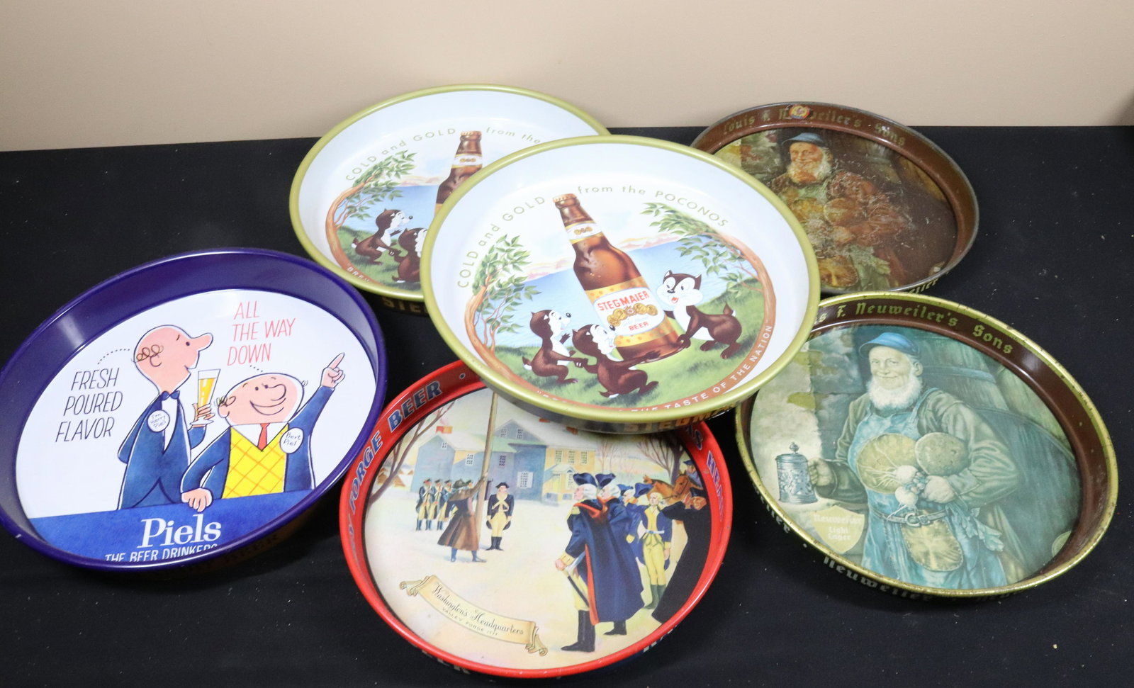 VINTAGE ADVERTISING BEER TRAU LOT: (6) INCLUDING - STEGMAIER, PIELS, VALLEY FORGE, AND NEUWILER'S Size: 11 1/2" TO 13" DIAMETER Terms: This is an On-Site Auction. Pick-up will be from Monday April 4th – Thursday April 7th from 9: