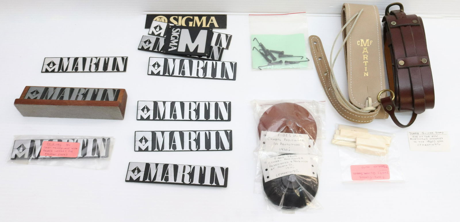 LOT OF VINTAGE MARTIN GUITAR ACCESSORIES: INCLUDING MARTIN NAME PLAQUES, PROTYPE SCRAPS, BONE HEAD KNOTS AND BRIDGES SIZE: TERMS: Please Read Carefully. Pick-Up will be 1 WEEK ONLY. June 20th through June 24th. Hartzell’s Auction Galler