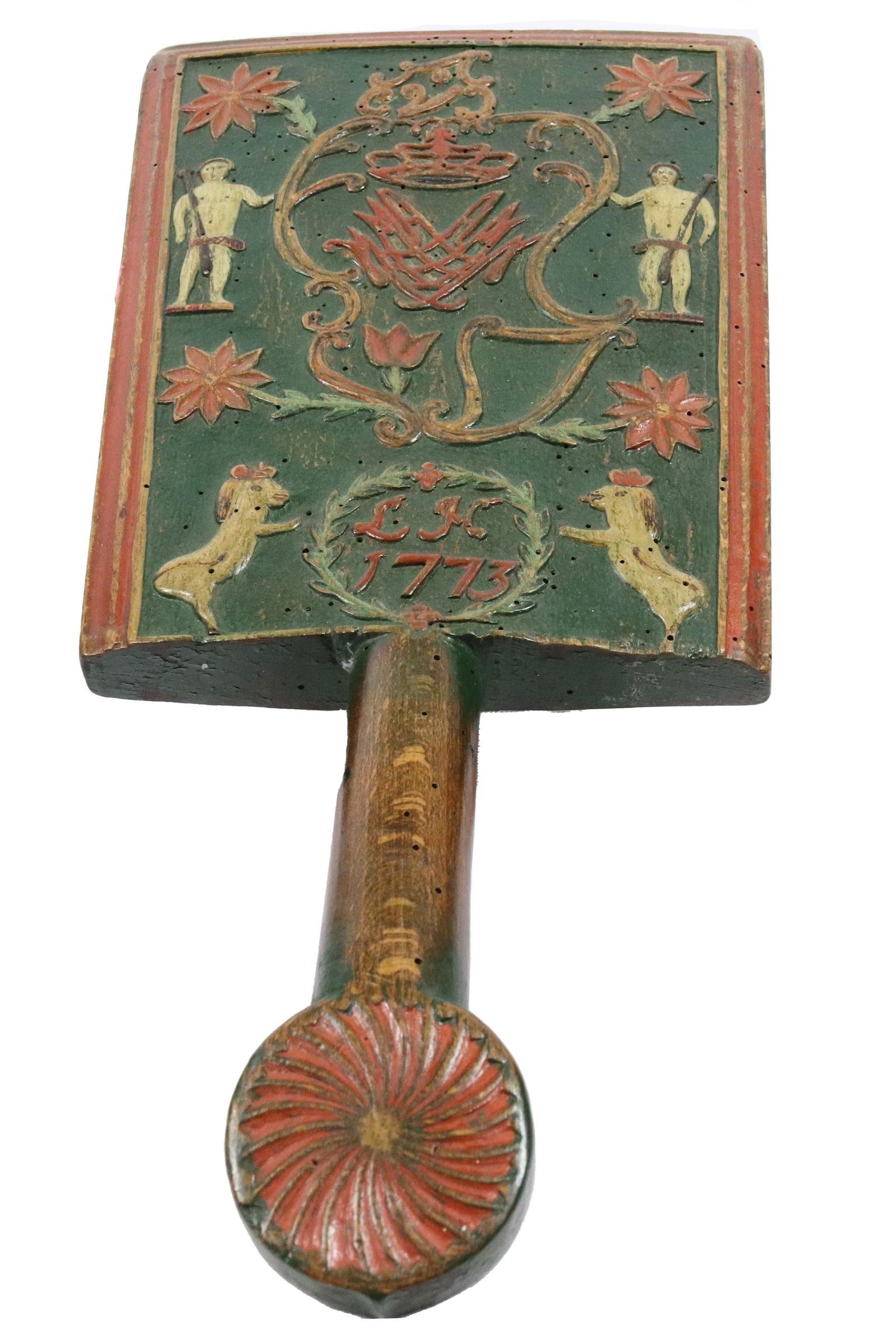 18TH C. EXQUISITELY CARVED WASHING BAT: DATED 1773, "LH" INITIALS IN WREATH. FLORAL CARVED ROSETTES WITH SOLDIERS HOLDING CROWN AND TWO HORSES. CARVED PINWHEEL HANDLE. 15" L