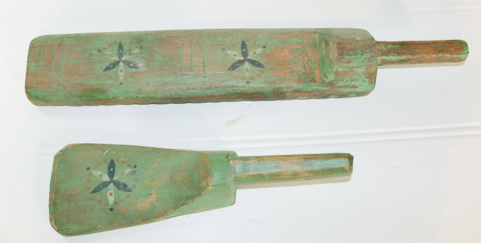 PAIR OF WOODEN WASHING BATS: PAINTED GREEN SURFACE WITH PINWHEEL DESIGN. ONE DATED 1896 Size: 14" AND 22 1/2" L Terms: PLEASE READ THIS CAREFULLY AND FULLY BEFORE BIDDING - THIS IS AN ON-SITE AND LIVE IN PERSON AUCTION. PREVIEW W