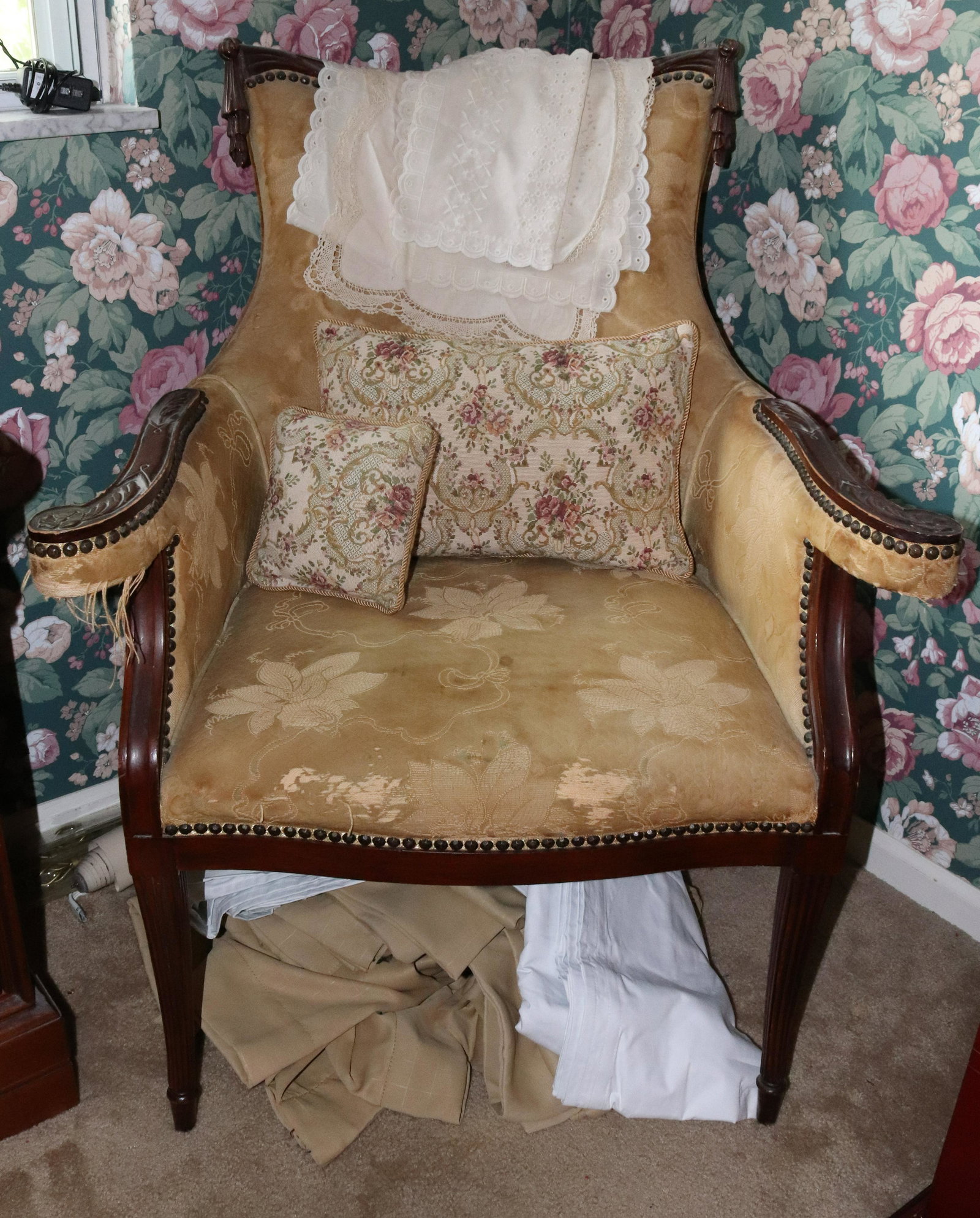 ANTIQUE CARVED CHAIR: VICTORIAN STYLE CARVED CHAIR WITH UPHOLSTERY, PILLOWS, AND CURTAINS