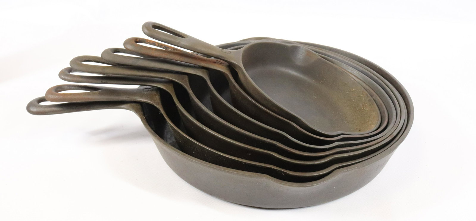 LOT OF GRISWOLD CAST IRON SKILLETS: (7) INCLUDING: #3 (709H), #4 (702A), #5 (724E), #6 (699), #7 (701A), #8 (704) AND #10 (716B). MEASURE 10 1/2" TO 16 3/4" TOTAL LENGTHS.