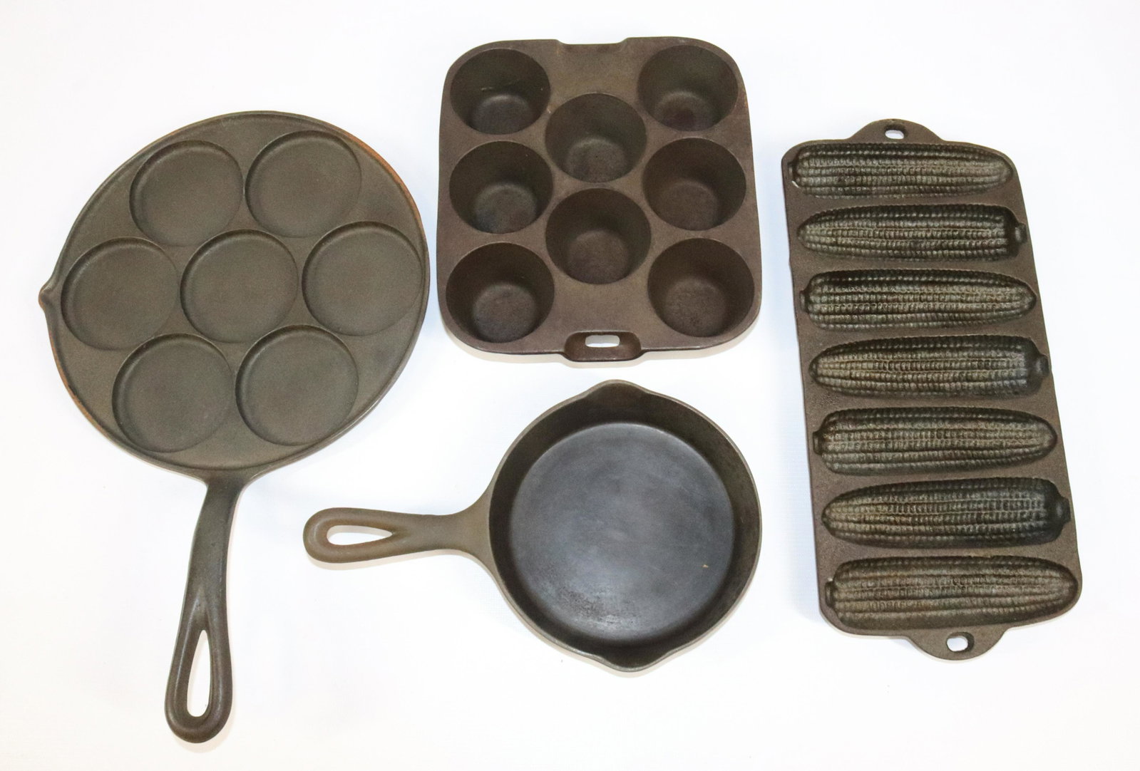 LOT OF CAST IRON WAGNER WARE ITEMS: INCLUDING: SWEDISH CAKE PAN 1316, #2 SKILLET, CORN MOLD PAN AND MUFFIN PAN R1336 (MEASURES 8 1/4" L)
