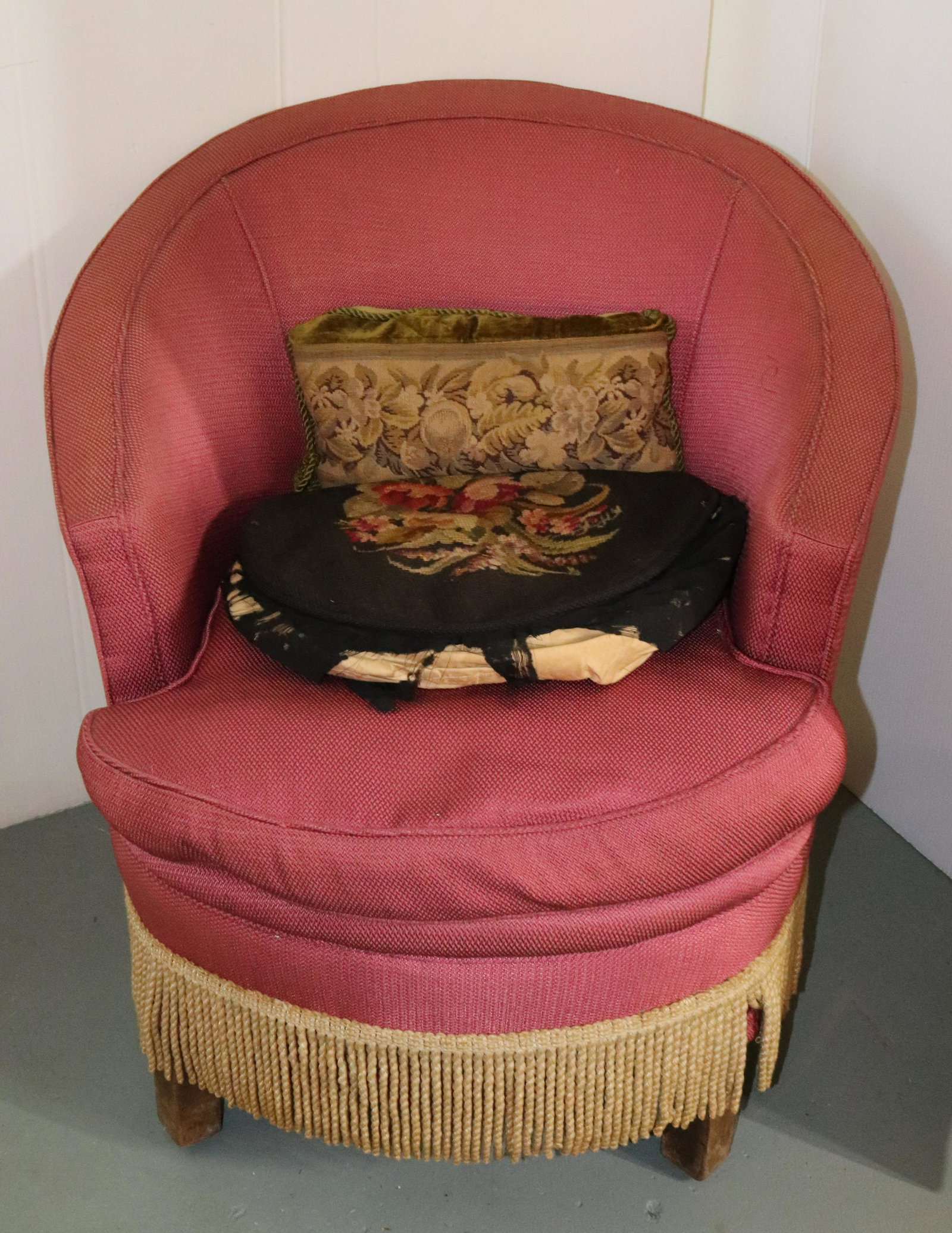 VINTAGE UPHOLSTERED CHAIR: BARREL-BACK STYLE WITH FRINGED EDGE. INCLUDES TWO PILLOWS. MEASURES 30" X 28" X 30". Terms: THIS IS AN ON-SITE ONLINE ONLY AUCTION. THE SALE ADDRESS IS 718 STOKES MILL RD. EAST STROUDSBURG, PA 18302. 