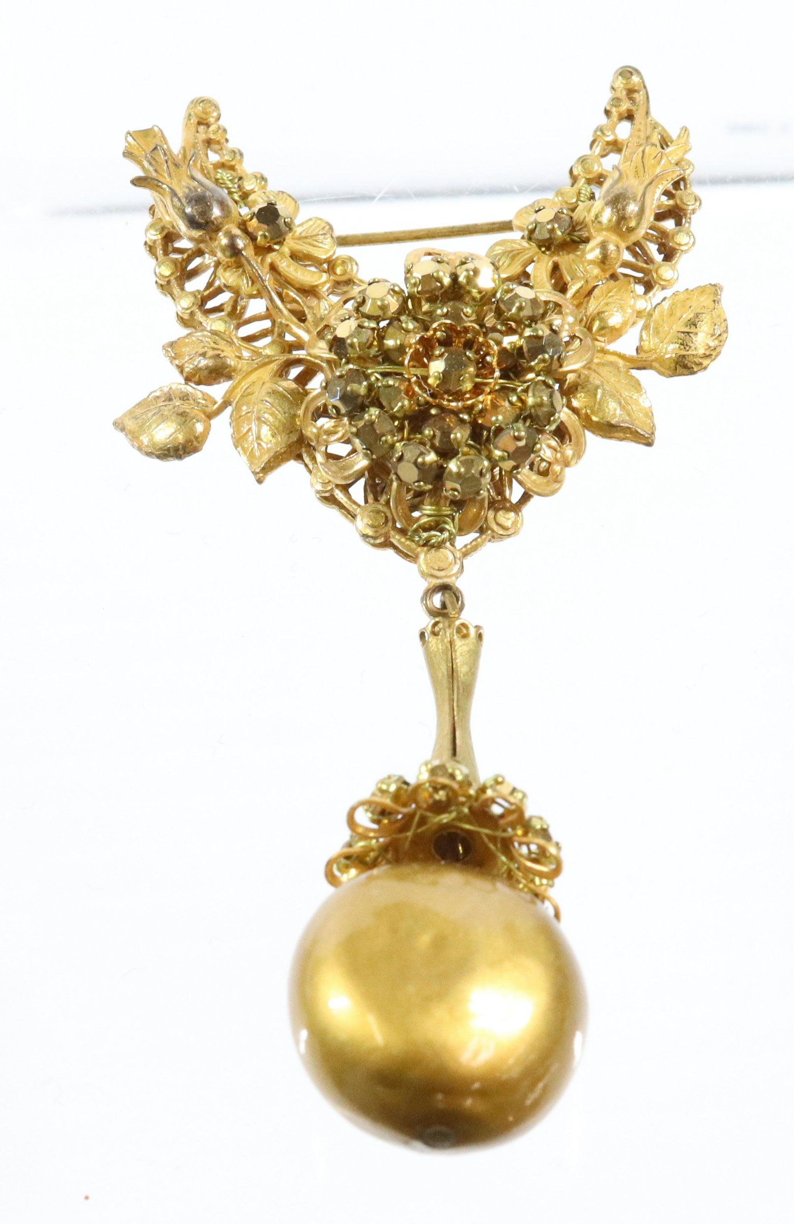 STANLEY HAGLER BROOCH: GOLDEN RHINESTONES WITH LARGE GOLD PEARL DROP WIRED CONSTRUCTION 3 1/2" X 2" UNMARKED Terms: THIS IS AN ON-SITE ONLINE ONLY AUCTION. THE SALE ADDRESS IS 718 STOKES MILL RD. EAST STROUDSBURG, PA 18302.