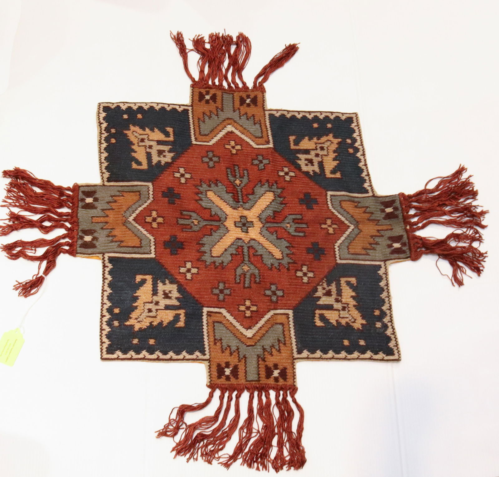 HANDMADE TABLETOP TEXTILE: MULTI-COLOR, FRINGED EDGES. MEASURES 26" X 26". Terms: THIS IS AN ON-SITE ONLINE ONLY AUCTION. THE SALE ADDRESS IS 718 STOKES MILL RD. EAST STROUDSBURG, PA 18302. THIS IS THE ESTATE OF CANDACE BRIGGS.