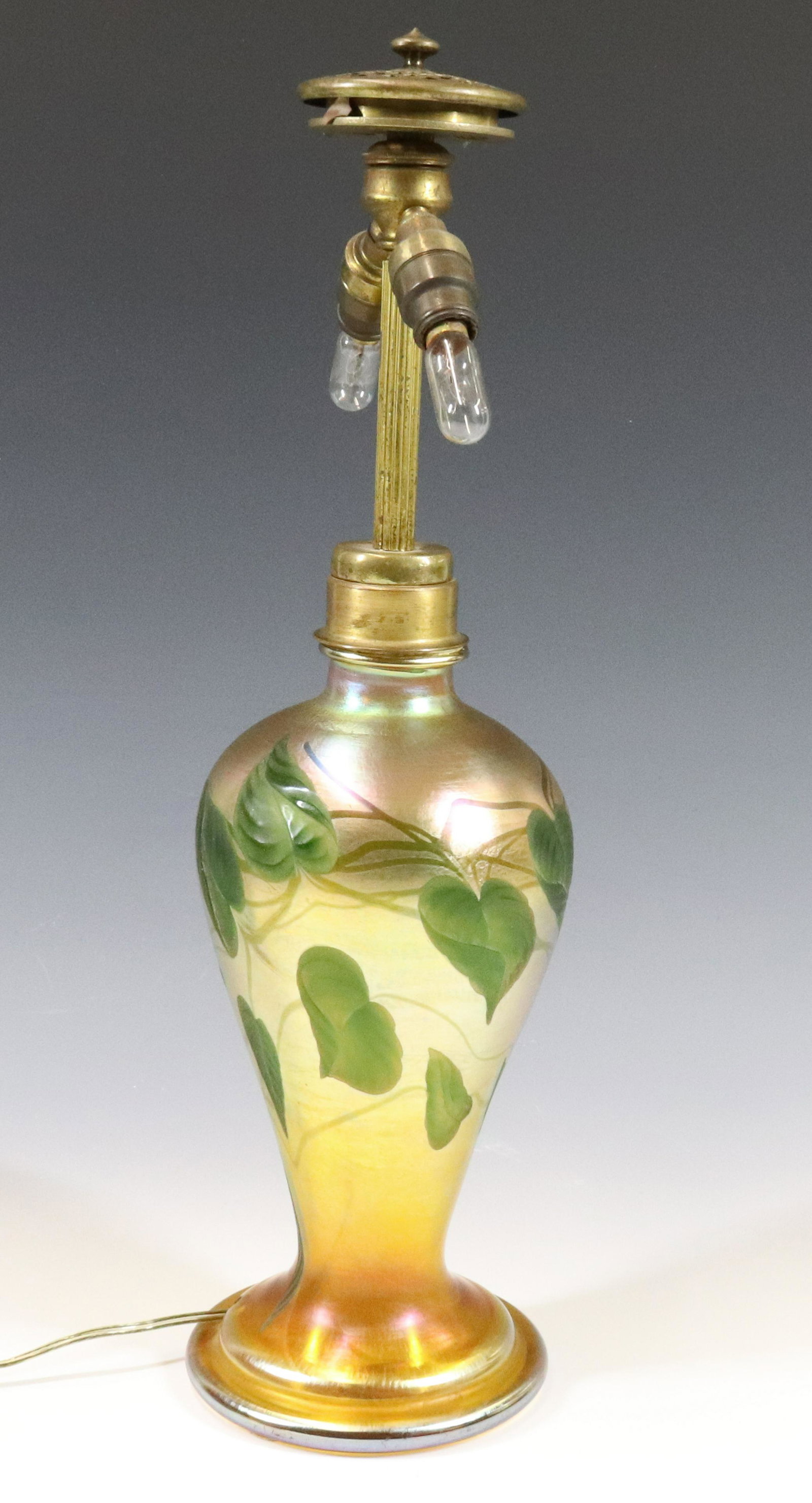 TIFFANY LEAF & VINE LAMP: GOLD AURENE WITH INTAGLIO CUT LEAVES AND ORIGINAL ELECTRIC FIXTURE/ SHADE CAP AND FINIAL SIGNED L.C.TIFFANY FAVRILE AND #862. 15"H X 4 1/4"