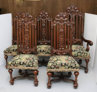 SET OF CARVED OAK DINING CHAIRS: INCLUDES: ONE ARMCHAIR AND RIGHT SIDE CHAIRS. UPHOLSTERED FLORAL SEATS WITH FRINGE. CARVED BACKS AND LEGS ON CASTERS. MEASURE 49" TO 55" H. Terms: Please read Carefully before bidding. This is