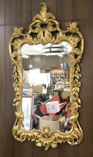 ORNATE GILT FRAMED MIRROR: FLORAL AND LEAVES MOTIF. MEASURES 55" X 28". Terms: Please read Carefully before bidding. This is a Two-Part Estate Sale. Pick-up for these sales will be Tuesday November 8th through Friday