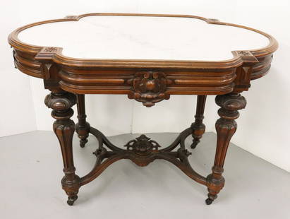 VICTORIAN MARBLE TURTLE TOP TABLE: WALNUT WITH WHITE MARBLE BASE STRETCHER WITH CENTER CARVING 30 1/2"H X 44 1/2" X 27 1/2" Terms: Please read Carefully before bidding. This is a Two-Part Estate Sale. Pick-up for these sales will be Tu