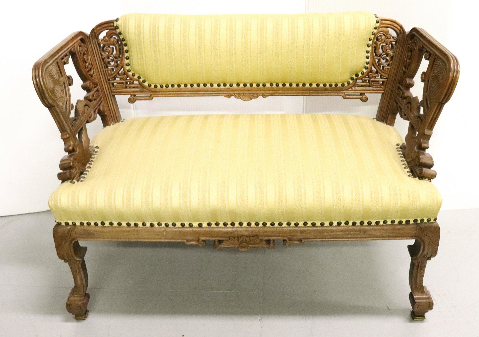 CHINESE CARVED SETTEE: UPHOLSTERED WITH DRAGONS AT BASE OF ARMS 19TH 27"H X 37" X 23" Terms: Please read Carefully before bidding. This is a Two-Part Estate Sale. Pick-up for these sales will be Tuesday November 8th through