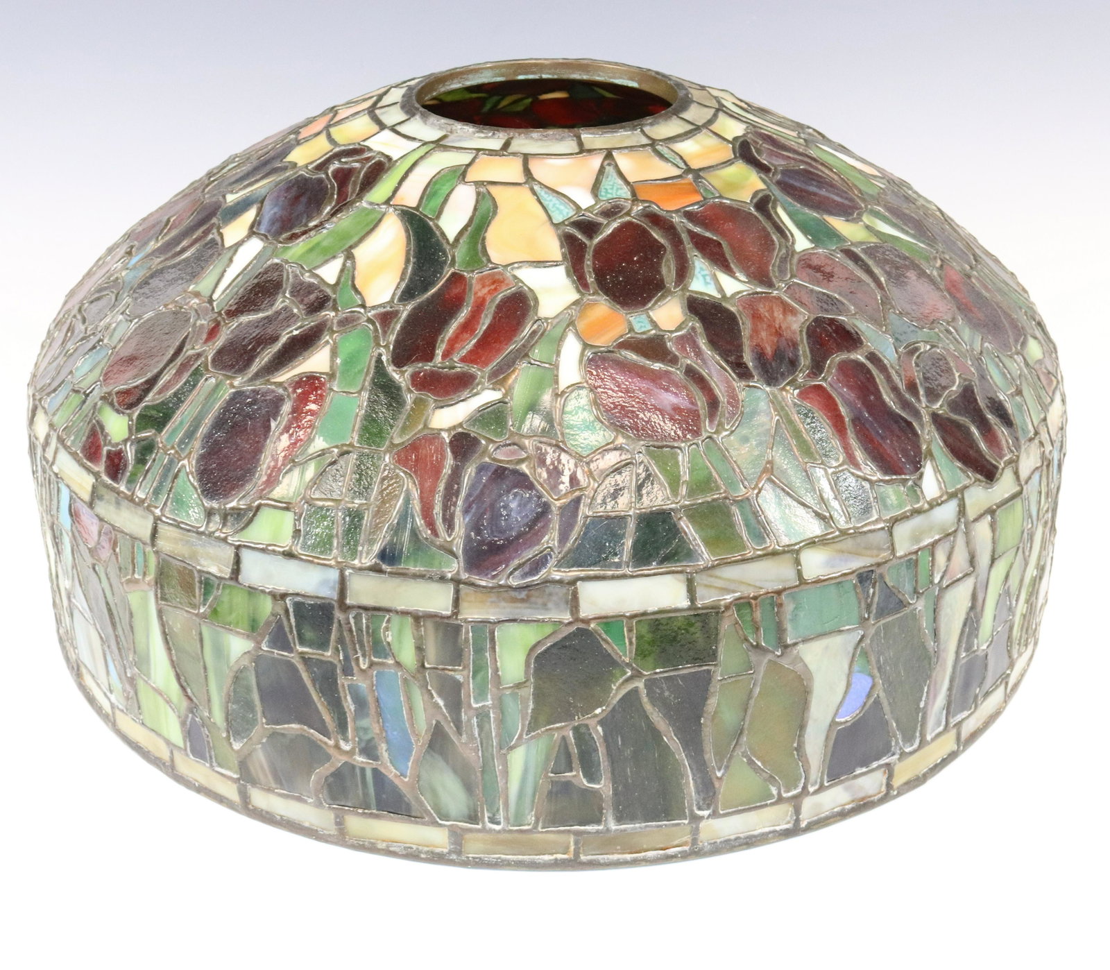 LEADED GLASS DOME SHADE: TULIPS AND FOLIAGE WITH BORDERS RUBY GREEN AND BUTTERSCOTCH COLORS 8 1/2"H X 18" Terms: Please read Carefully before bidding. This is a Two-Part Estate Sale. Pick-up for these sales will be Tuesday No