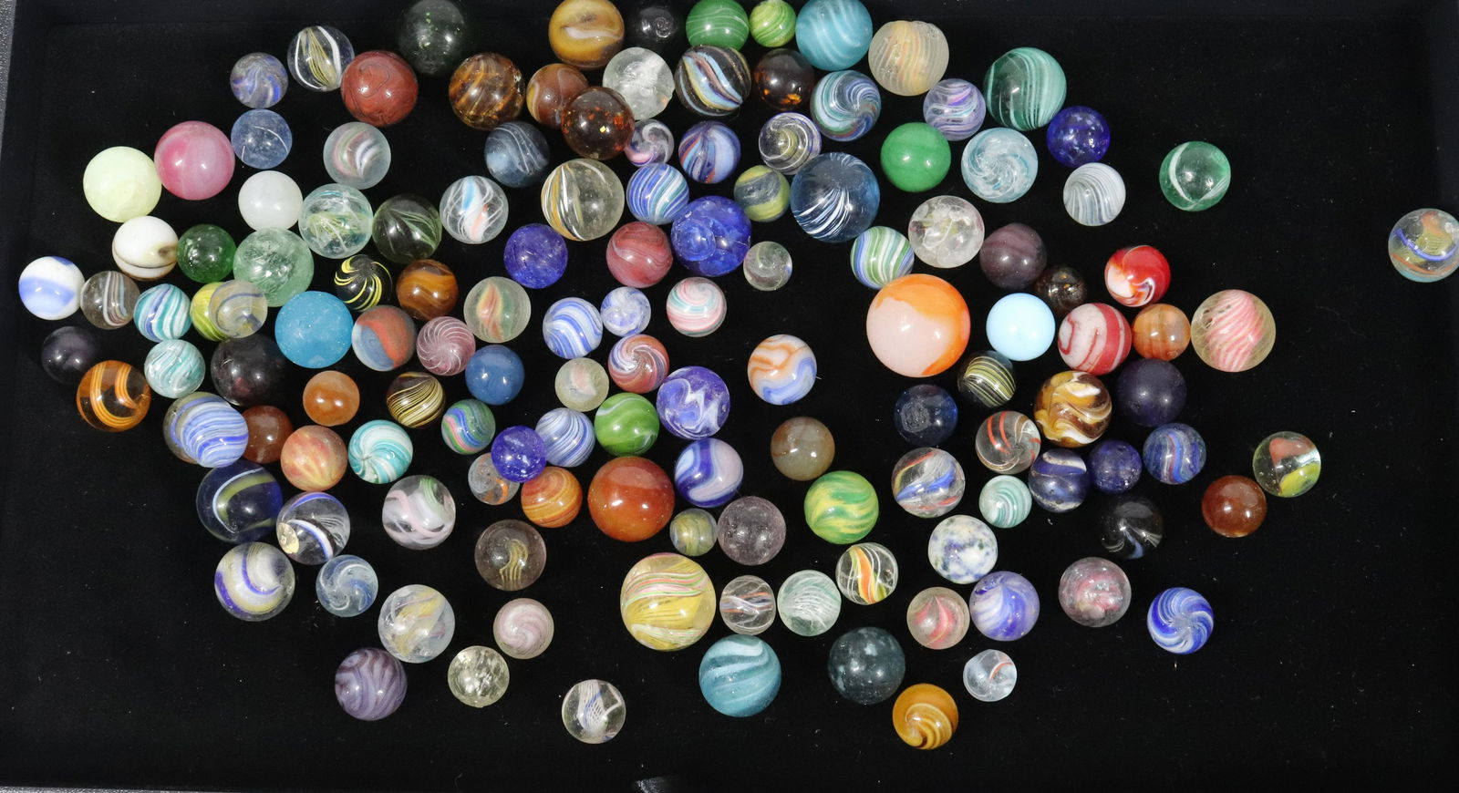 VINTAGE LOT OF MARBLES: APPROXIMATELY 115 INCLUDING - SWIRLS, ONION SKINS, SOLID, AND OTHER FORMS Please Read Carefully before Bidding. Hartzell’s Auction Gallery Inc. will Conduct an ON-SITE and also ON-LINE Auction a