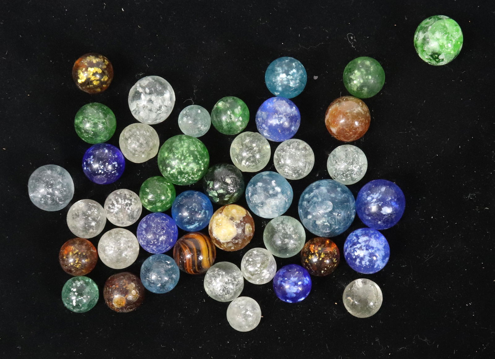 VINTAGE MARBLE LOT: APPROXIMATELY 40 GLASS MARBLES WITH FLECKING - LARGEST 15/16" Please Read Carefully before Bidding. Hartzell’s Auction Gallery Inc. will Conduct an ON-SITE and also ON-LINE Auction at 2481 Belvi