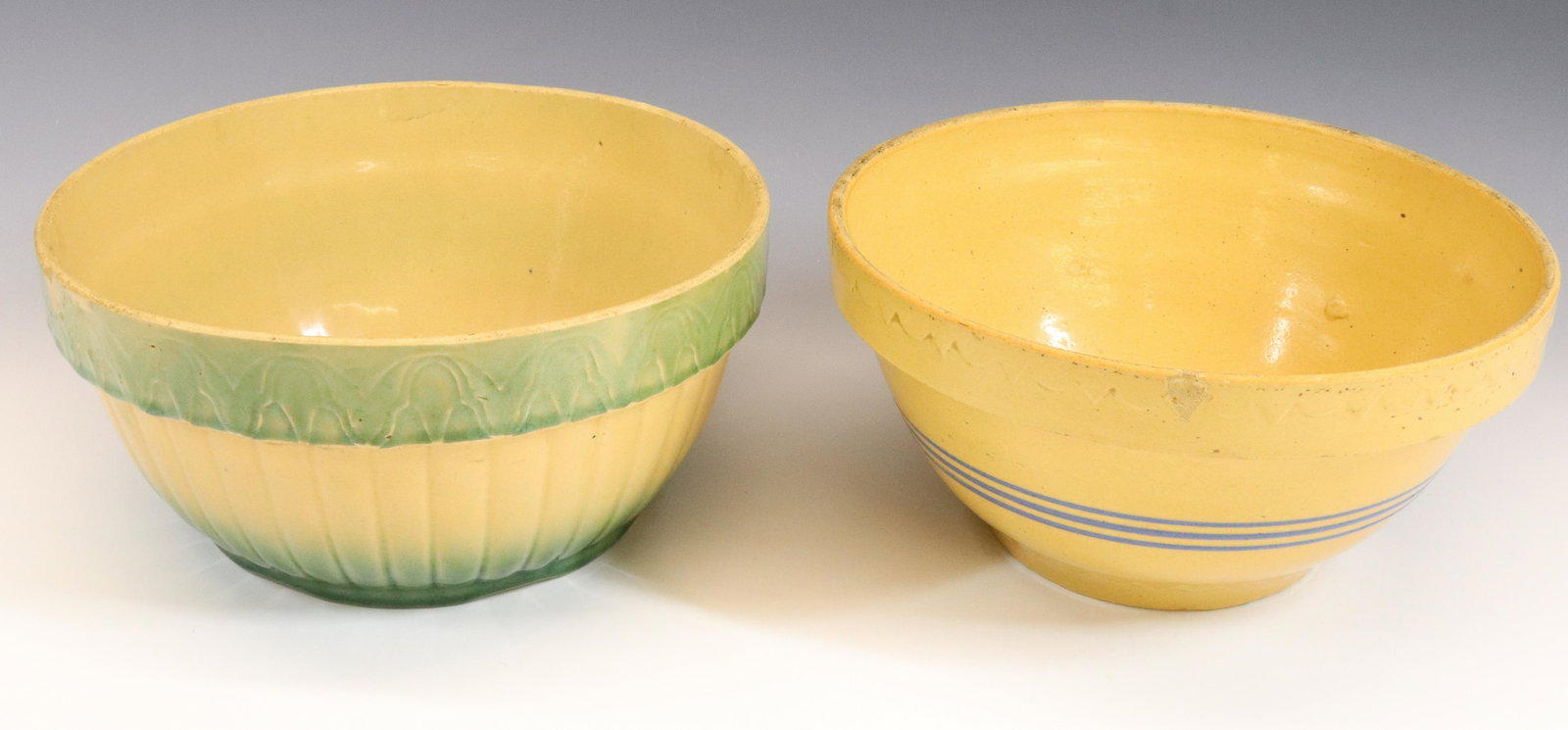 (2) YELLOWARE MIXING BOWLS: BLUE BANDED MIXING BOWL (MRKD. 143) AND GREEN/YELLOW EMBOSSED BOWL. MEASURE 10 1/2" D.