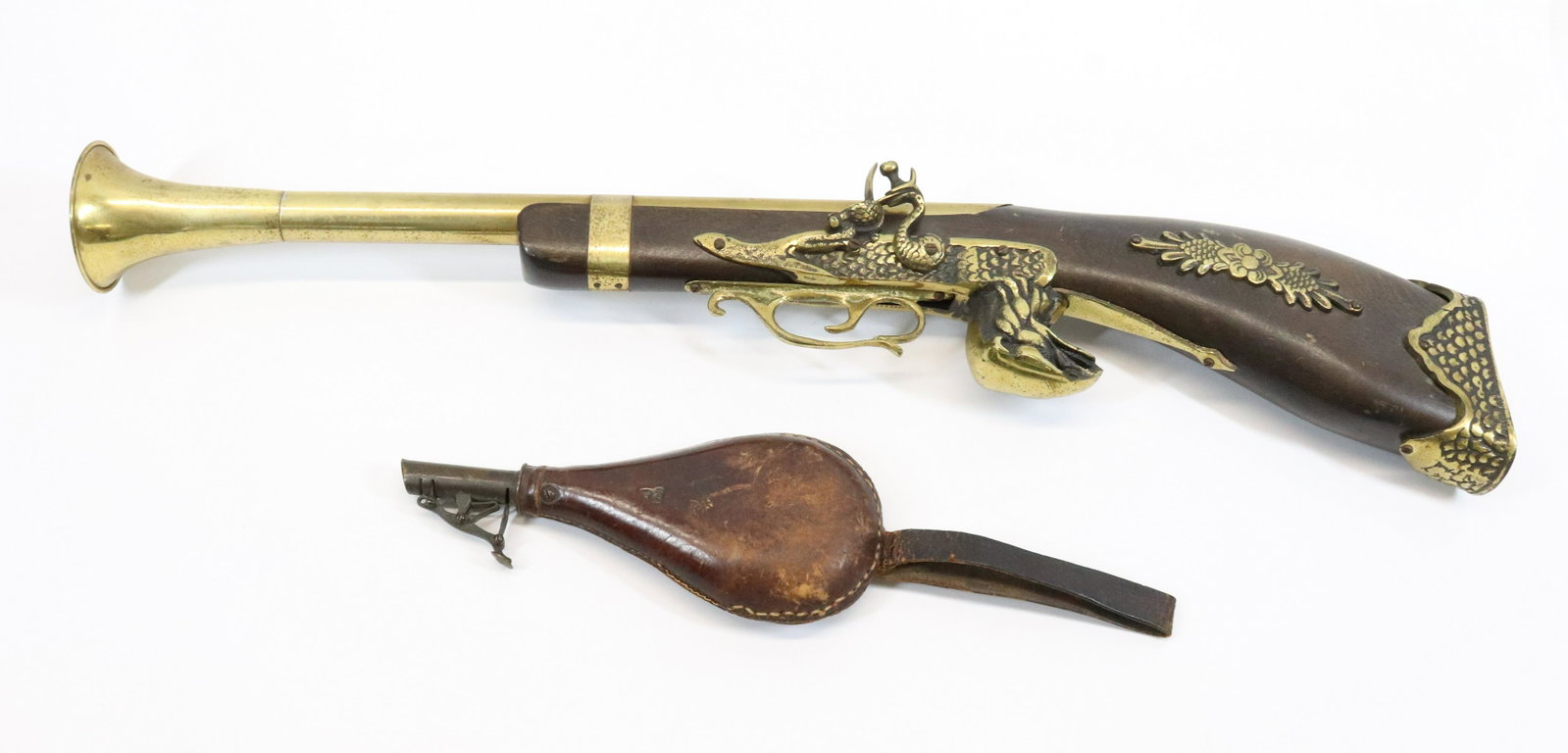 REPLICA BLUNDERBUSS AND POWDER FLASK: WOOD AND ORNATE BRASS REPLICA GUN (27" L). WITH, LEATHER/BRASS POWDER FLASK.