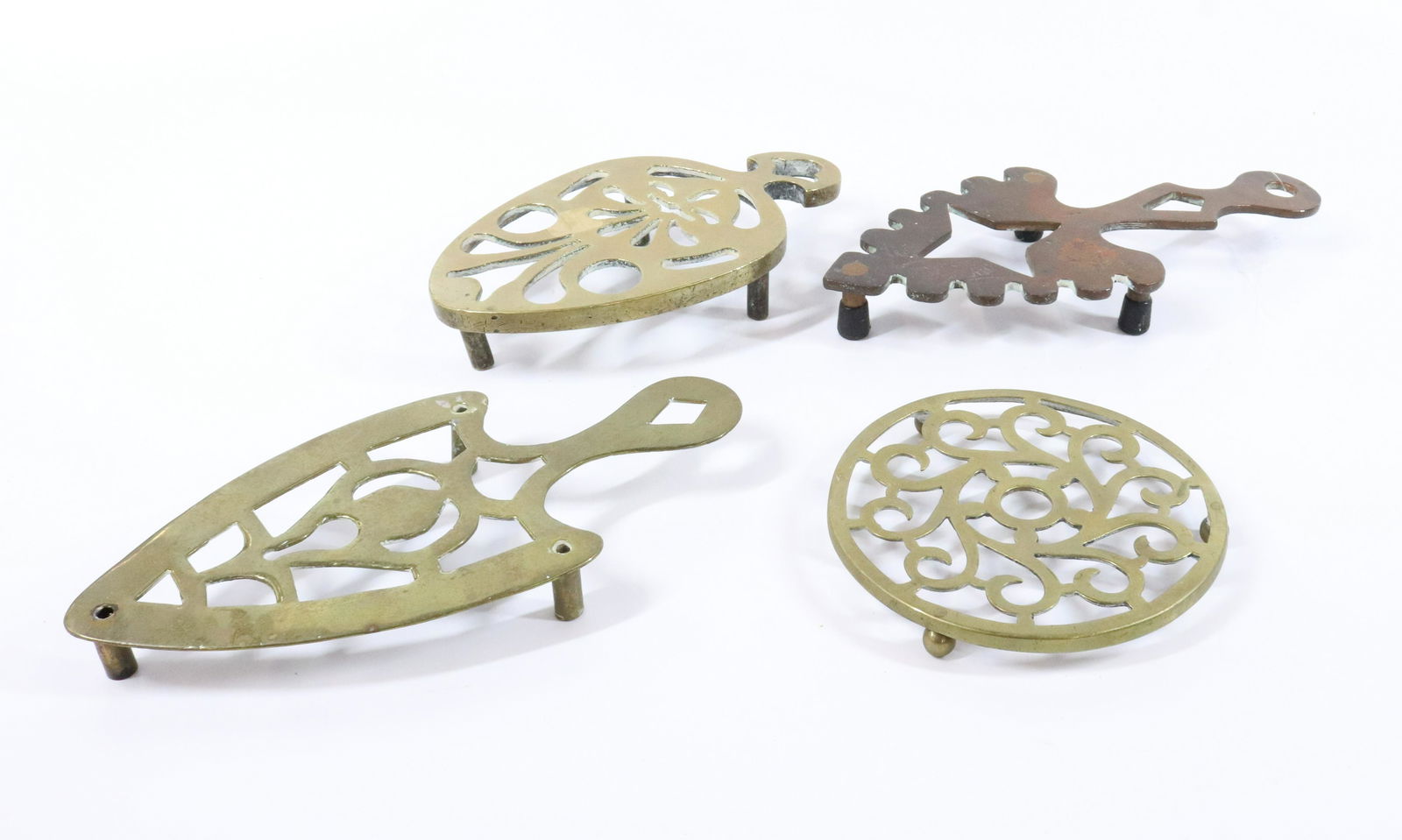 LOT OF BRASS TRIVETS: (4) CUT-OUT TRIVETS. MEASURE 5 1/2" TO 10" L. UPDATED 2023 Terms for Purchasing and Shipping of Auction Items. Please read carefully before bidding. All payments for purchases will be made through Liv