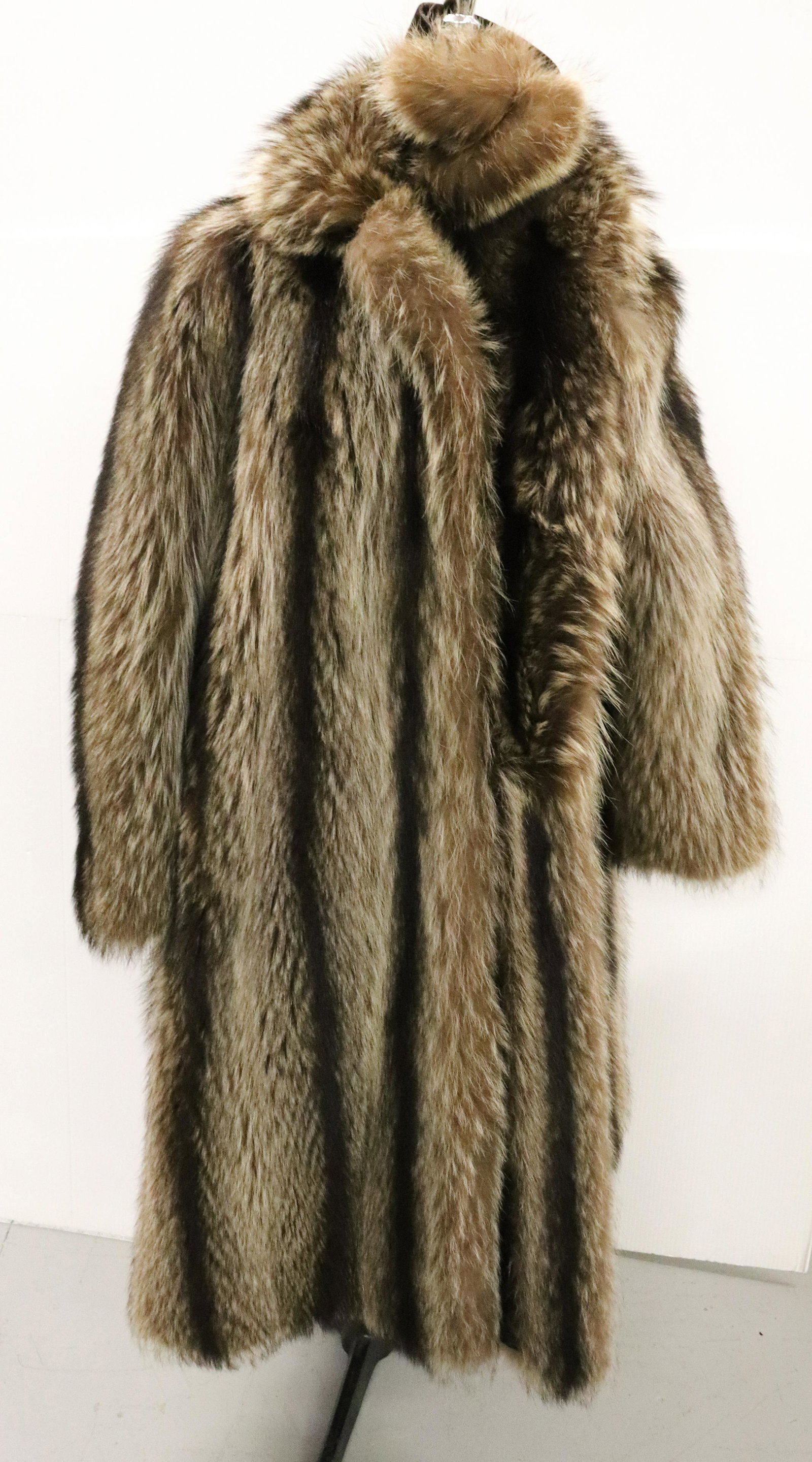 VINTAGE RACOON COAT AND EARMUFFS: 3/4 LENGTH. "LABELED "BENIOFF'S, ALLENTOWN" WITH EMBROIDERED NAME. PAISLEY INTERIOR. MEASURES 41 1/2" L. SIZE SMALL. UPDATED 2023 Terms for Purchasing and Shipping of Auction Items. Please read carefu