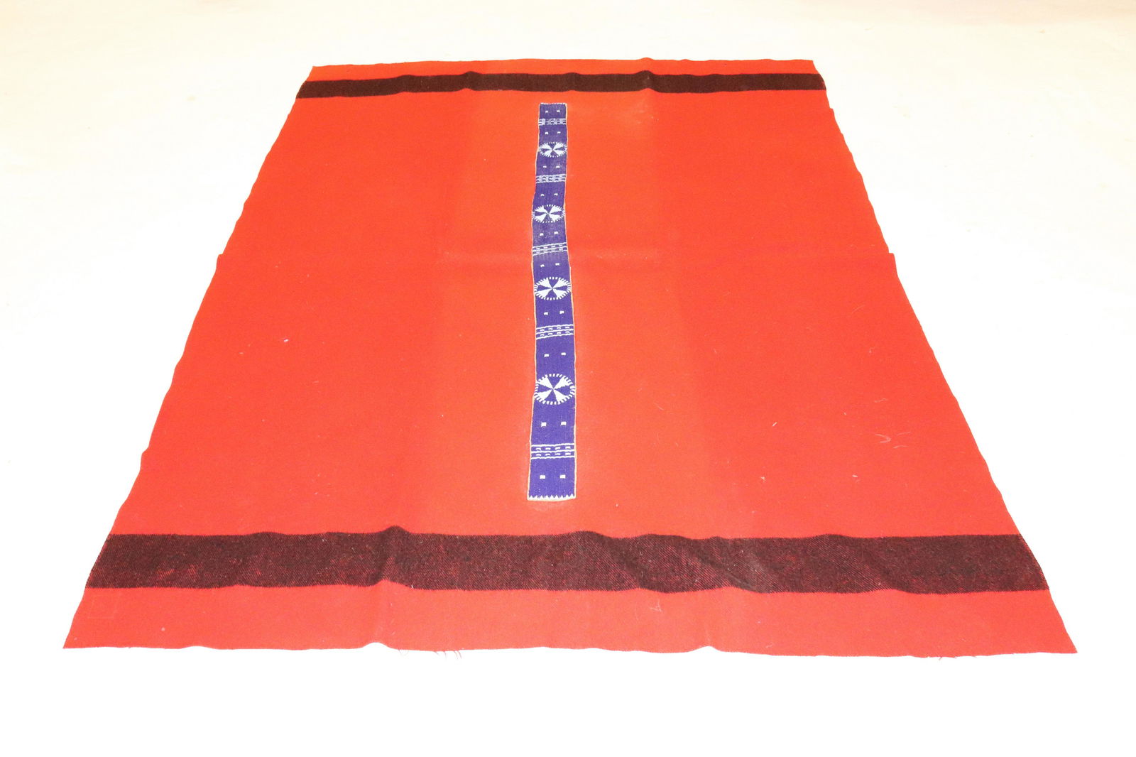 BEADED HIDE BLANKET STRIP: BEADED STRIP SEWN ON RED/BLACK HORN BROS. WOOL BLANKET. BLANKET 89" X 67". STRIP 63 1/2" L. UPDATED 2023 TERMS FOR PURCHASING AND SHIPPING OF AUCTION ITEMS. PLEASE READ CAREFULLY BEFORE BIDDING. ALL P