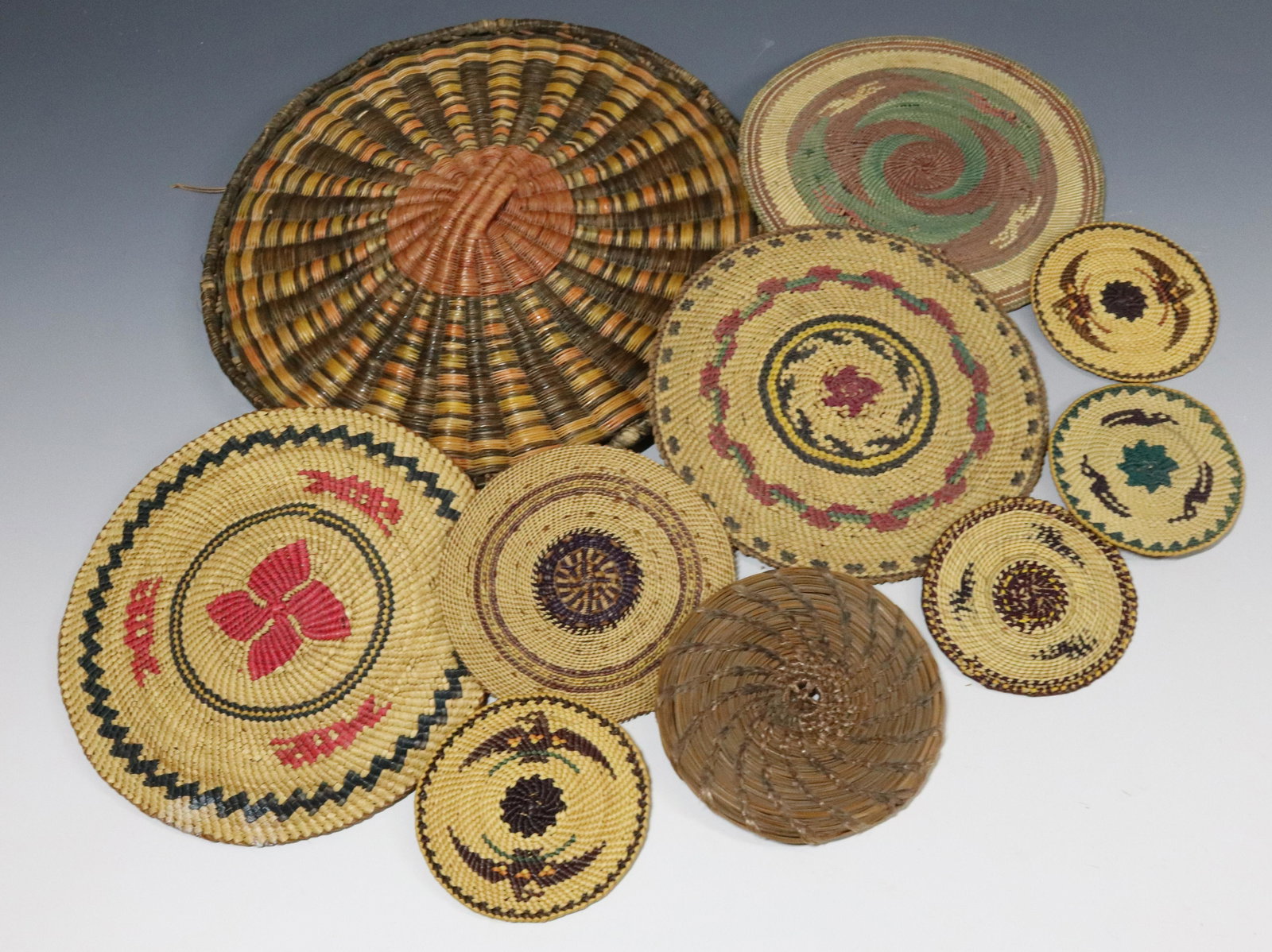 GROUP LOT OF WOVEN MATS: BASKET WOVEN MATS IN VARIOUS SIZES AND COLORS - NORTHWEST COAST, 3 1/8" TO 10 1/4" UPDATED 2023 TERMS FOR PURCHASING AND SHIPPING OF AUCTION ITEMS. PLEASE READ CAREFULLY BEFORE BIDDING. ALL PAYMENTS F