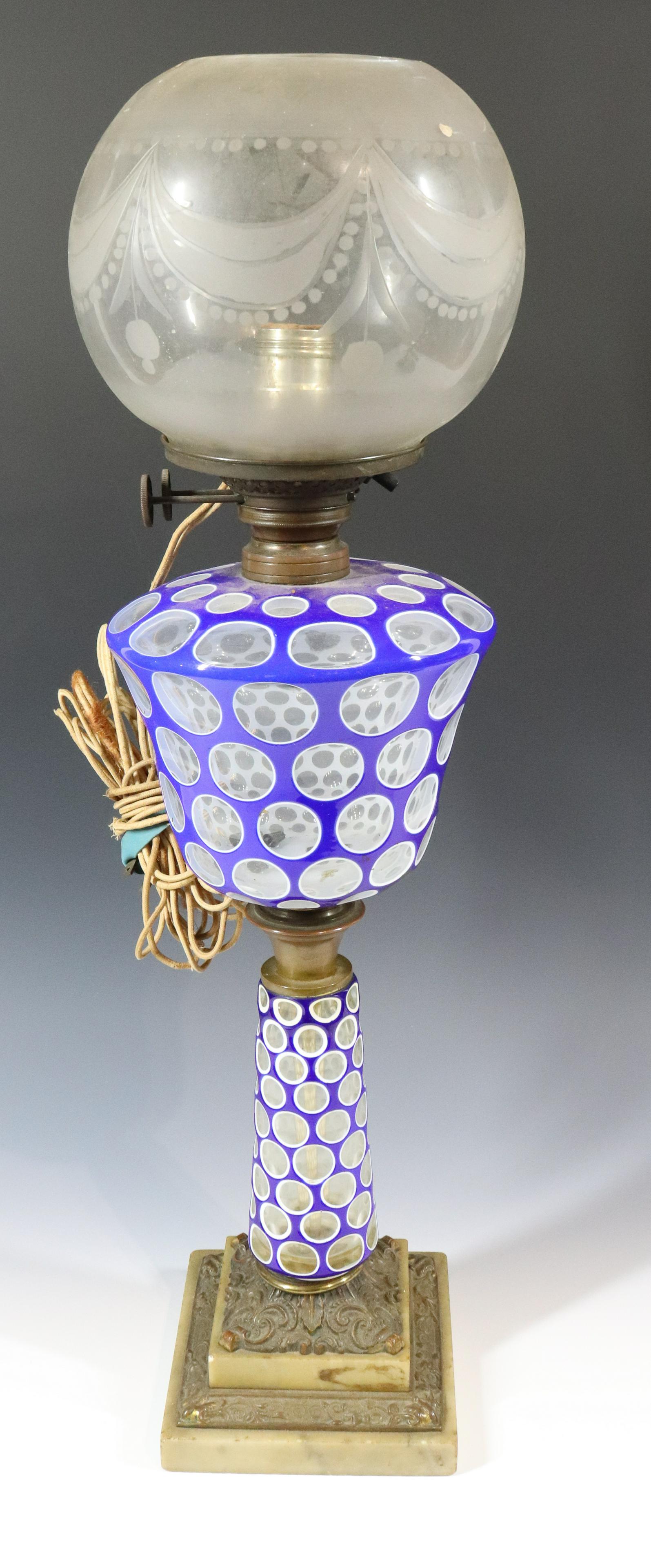 19TH CENTURY BOSTON AND SANDWICH GLASS BANQUET LAMP: BLUE CUT TO WHITE TO CLEAR OVERLAY LAMP, AMERICAN CA. 1865. MEASURES 24 1/4" TOTAL HEIGHT. Please Read Carefully before Bidding. Hartzell’s Auction Gallery Inc. will Conduct an ON-SITE and also 