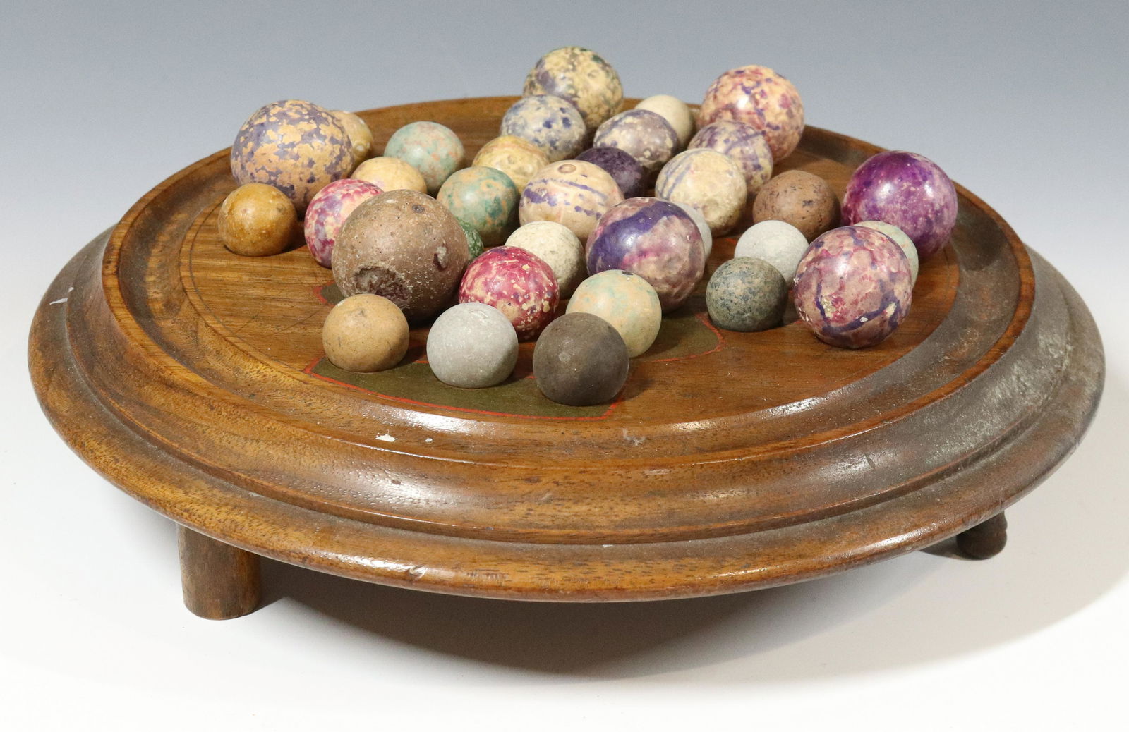 LOT OF CLAY MARBLES AND WOODEN GAME STAND: VARIOUS COLORS AND SIZES, BASE HAS SLIDE OUT DRAWER - 9" D Please Read Carefully before Bidding. Hartzell’s Auction Gallery Inc. will Conduct an ON-SITE and also ON-LINE Auction at 2481 Belvider