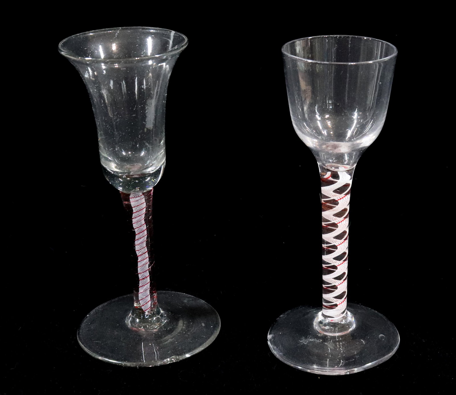TWO COLOR TWIST WINE GLASSES: ONE WITH FLARED RIM RED WITH WHITE AND RED AND WHITE TWIST EARLIER FORM 6 1/8"H Please Read Carefully before Bidding. Hartzell’s Auction Gallery Inc. will Conduct an ON-SITE and also ON-LINE Auc