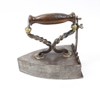 19TH C. FRENCH BOX IRON: TWISTED HANDLE WITH BRASS ESCUTCHEONS, FANCY REAR LIFT-GATE WITH HEART SCREW HEAD. EXTENDED REAR SOLE PLATE. 7 1/2" L. Terms: PLEASE READ CAREFULLY BEFORE BIDDING. THIS IS AN ONLINE ONLY AUCTION. PREV