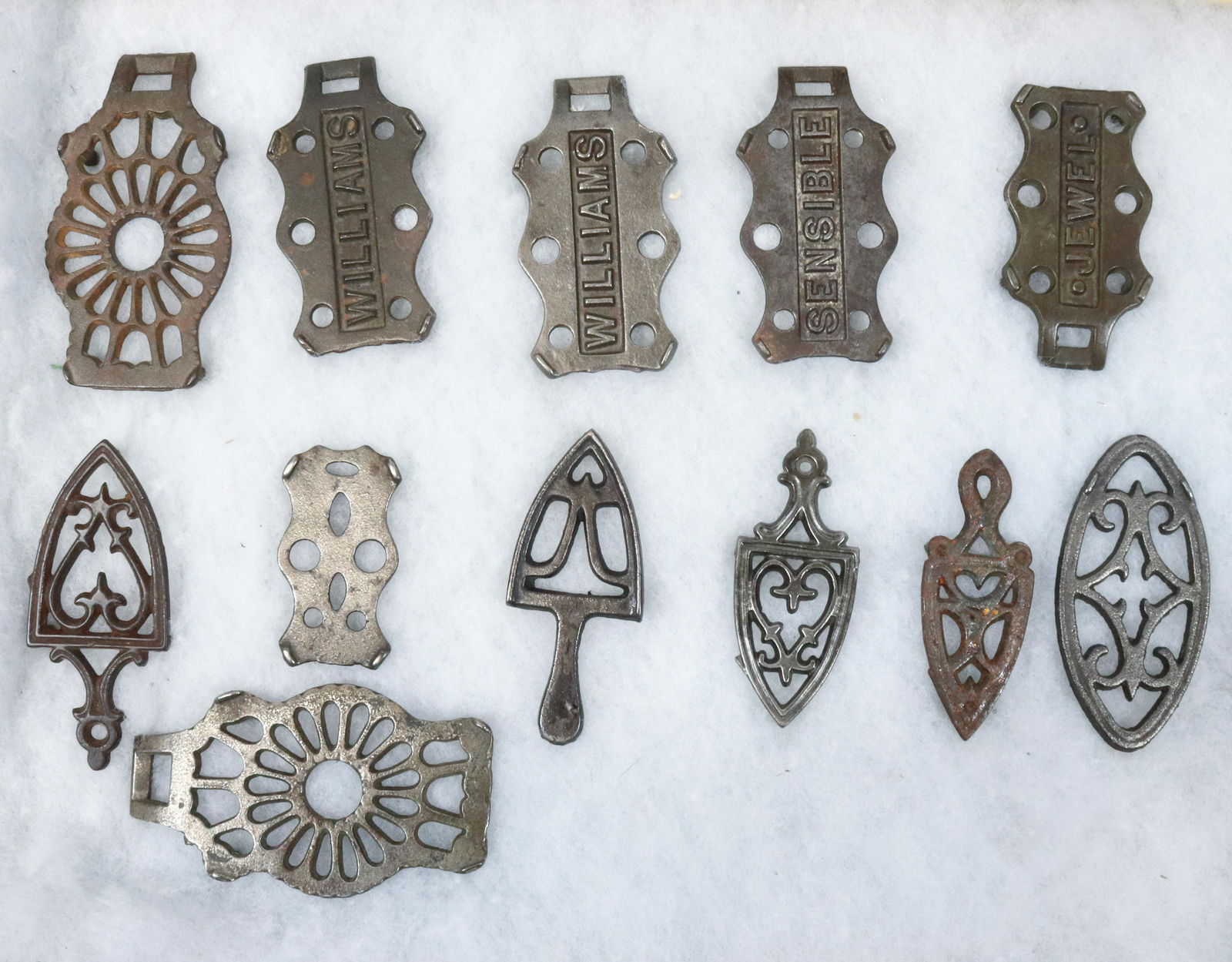 LOT OF MINIATURE TRIVETS: (12) MINIATURE TRIVETS INCLUDING: JEWELL, TC447, SENSIBLE, TC445, TWO WILLIAMS TC 446 AND OTHERS. 3" TO 4 1/2" L. Terms: PLEASE READ CAREFULLY BEFORE BIDDING. THIS IS AN ONLINE ONLY AUCTION. PREVIEWS