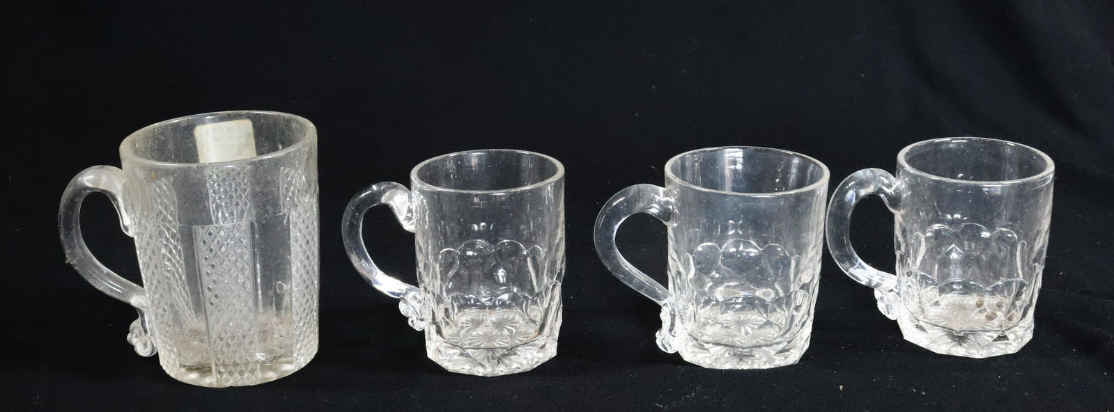 (4) PATTERN GLASS MUGS: ALL HAVE HANDLES WITH NICE CURL OR ENDING, THREE HONEYCOMB FLINT GLASS, NON FLINT PATTERN MUG 3 1/2" 4" Terms: Please Read Carefully before Bidding. Hartzell’s Auction Gallery Inc. will Conduct an O