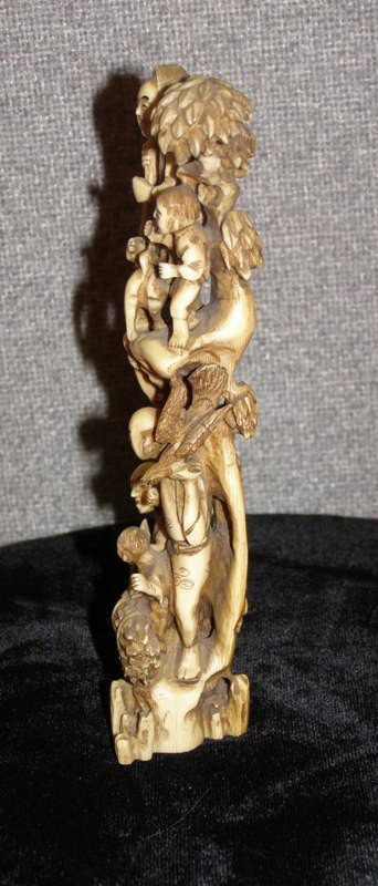 CARVED IVORY TOTEM POLE STYLE NETSUKE WITH GOOD R: CARVED IVORY TOTEM POLE STYLE NETSUKE WITH GOOD RELIEF CARVING OF DOG AND FIGURES 6 1/4"