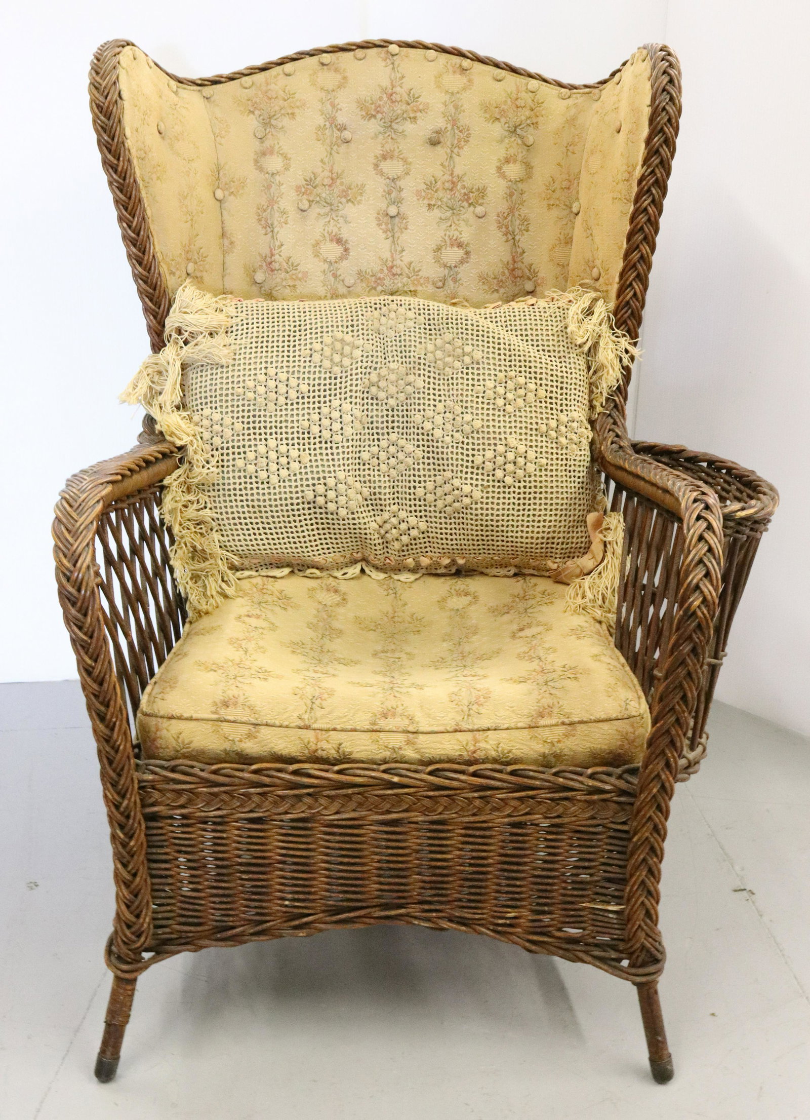 HEYWOOD BROTHERS WAKEFIELD CO. ARMCHAIR: WINGBACK WITH MAGAZINE HOLDER. UPHOLSTERED BACK AND CUSHION. LABELED UNDERNEATH. 41" X 31" X 25". TERMS: UPDATED 2023 TERMS FOR PURCHASING AND SHIPPING OF AUCTION ITEMS. PLEASE READ CAREFULLY BEFORE B
