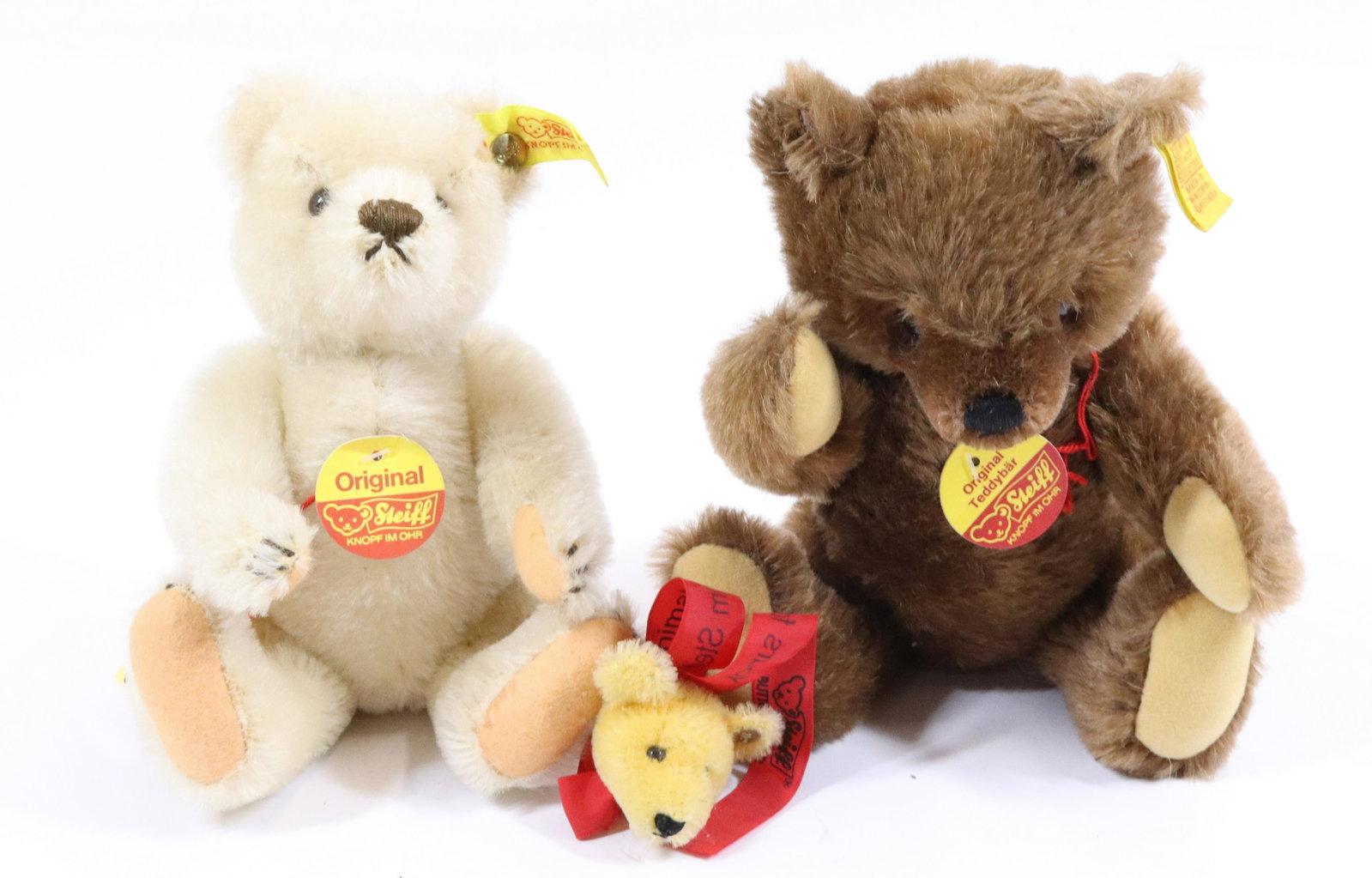 (2) STEIFF BEARS AND BEAR HEAD PIN: BUTTON/TAGS UN EAR WITH PAPER TAGS. 8" AND 9" LENGTHS. PIN HAS SOME WEAR TO RIBBON.